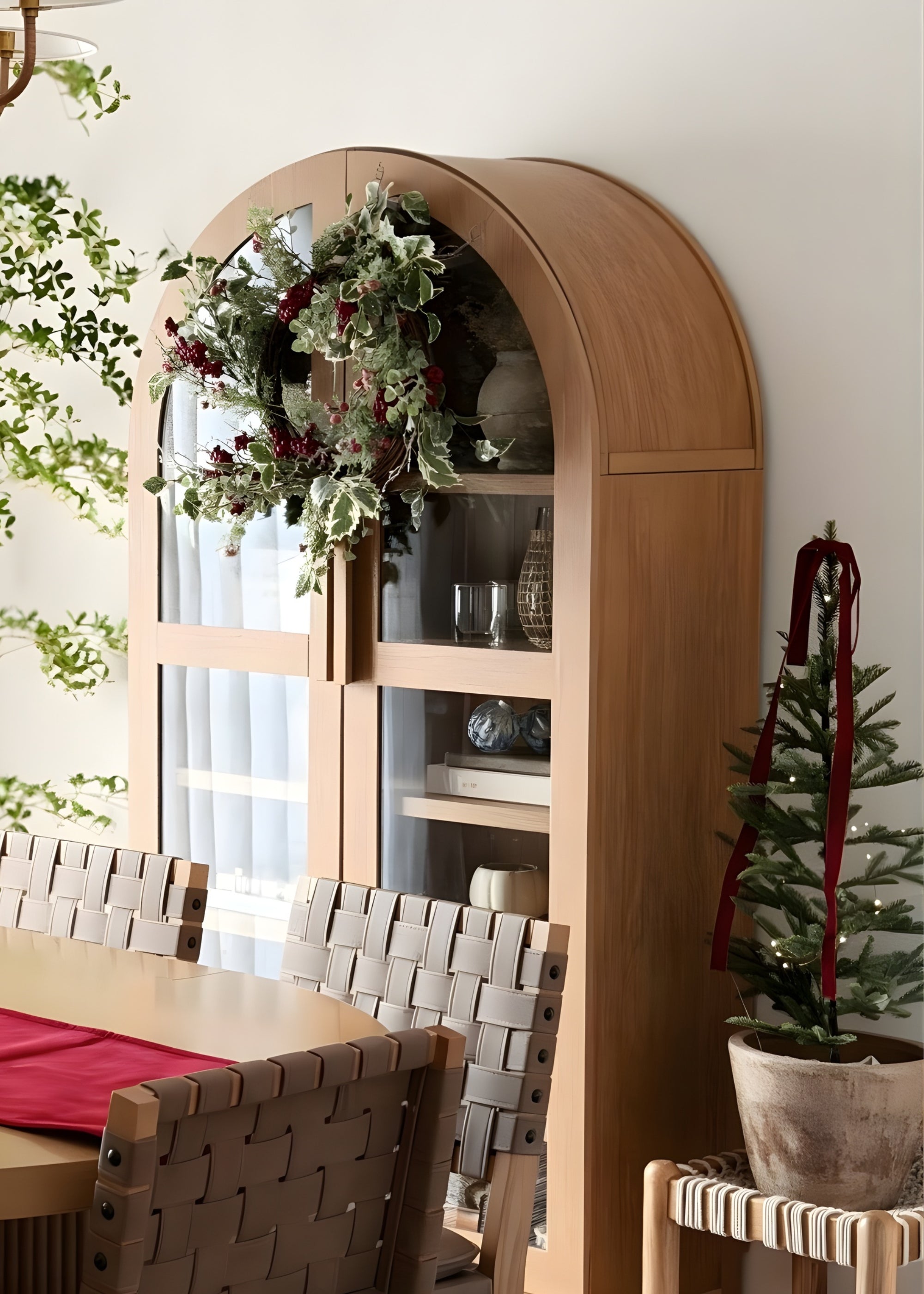 arched cabinet styled with frosted holly holiday wreath