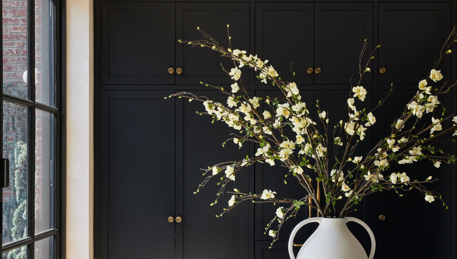cream white blossom branches arranged in vase