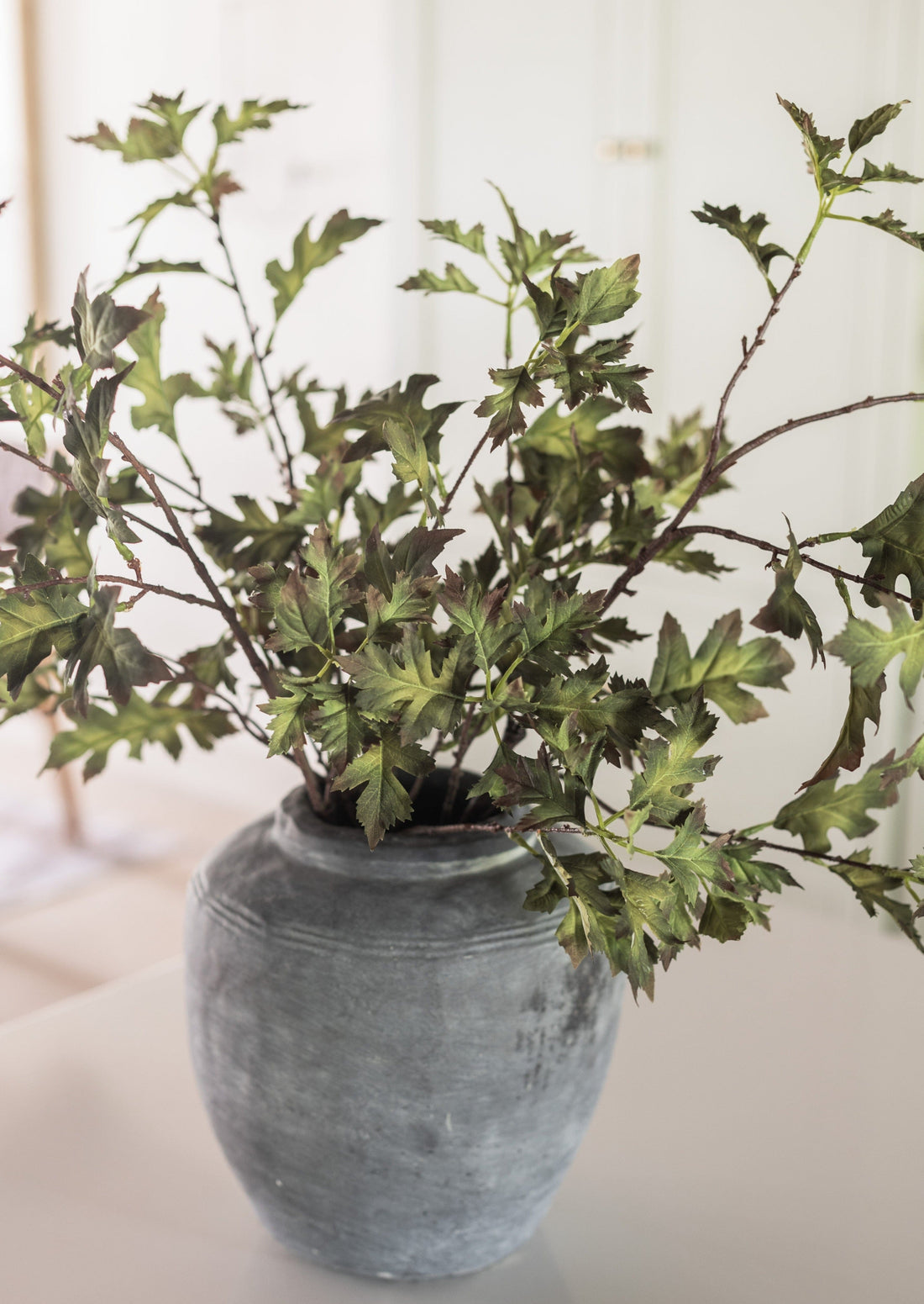 Faux Hawthorn Leaf Branches Styled in Rustic Concrete Vase