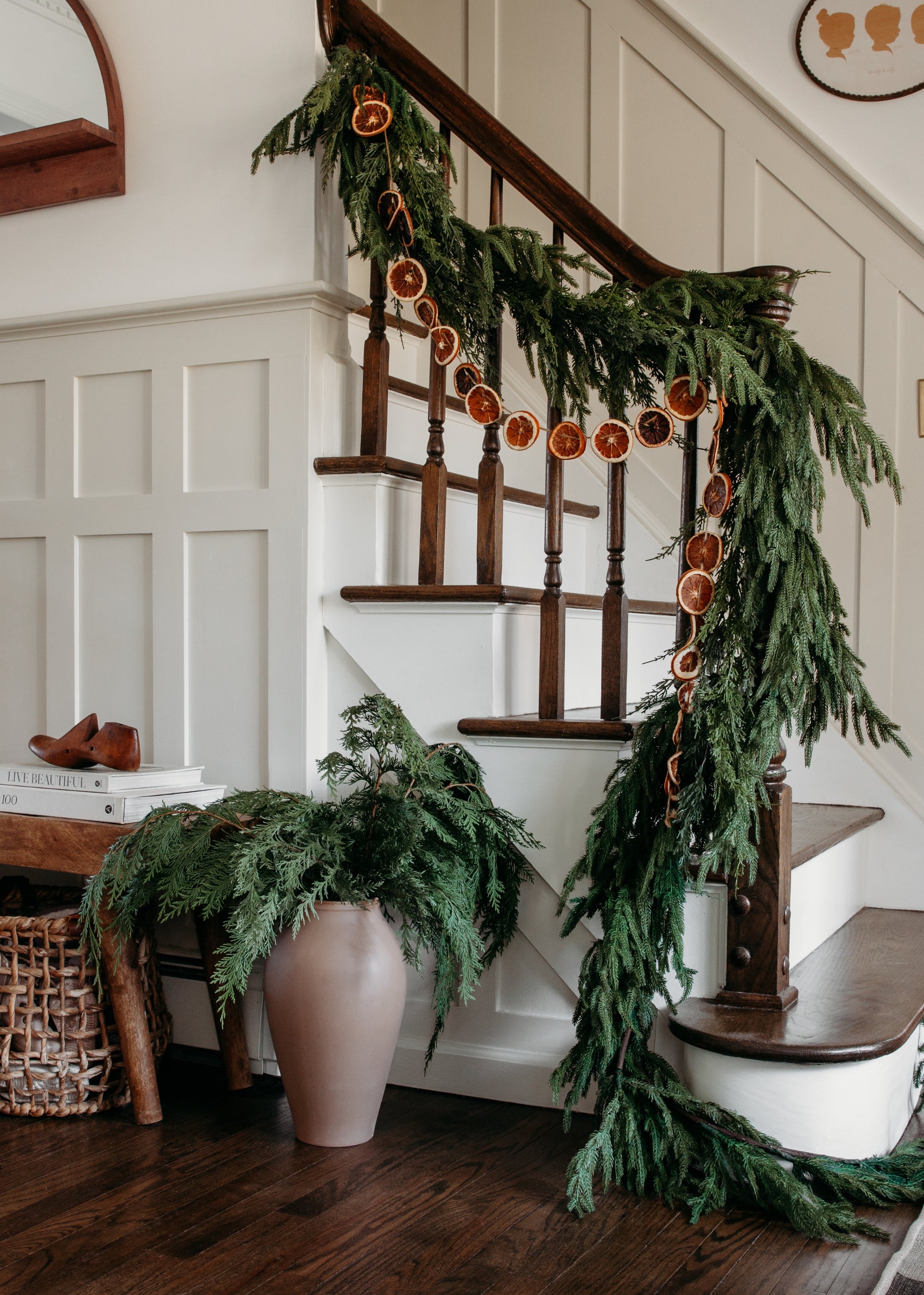 Afloral Real Touch Norfolk Garland and Orange Slice Garland on a Banister