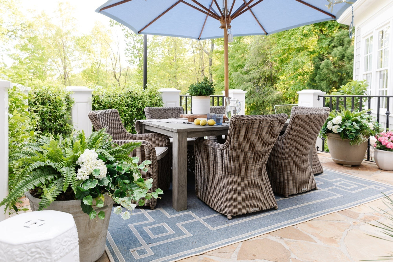 Outdoor patio seating with artificial flowers and plants.