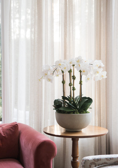 afloral faux potted orchid flower arrangement styled on table stand