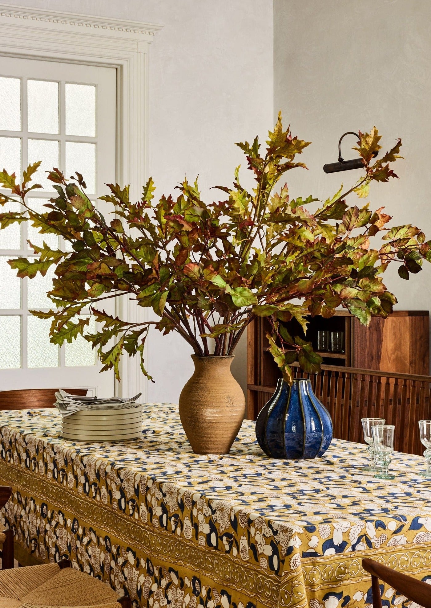 Fall-Inspired Dining Table Setting with Faux Oak Branch Arrangement at Afloral