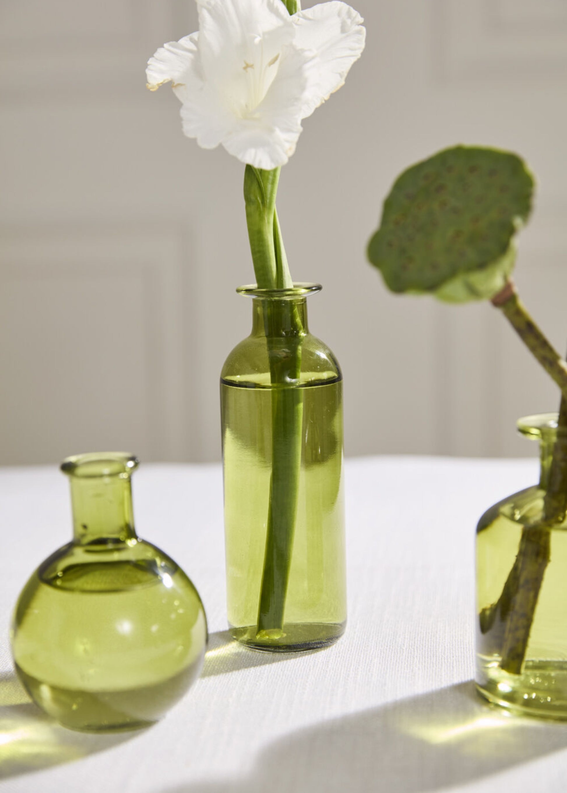 Three green glass bottles with flowers 