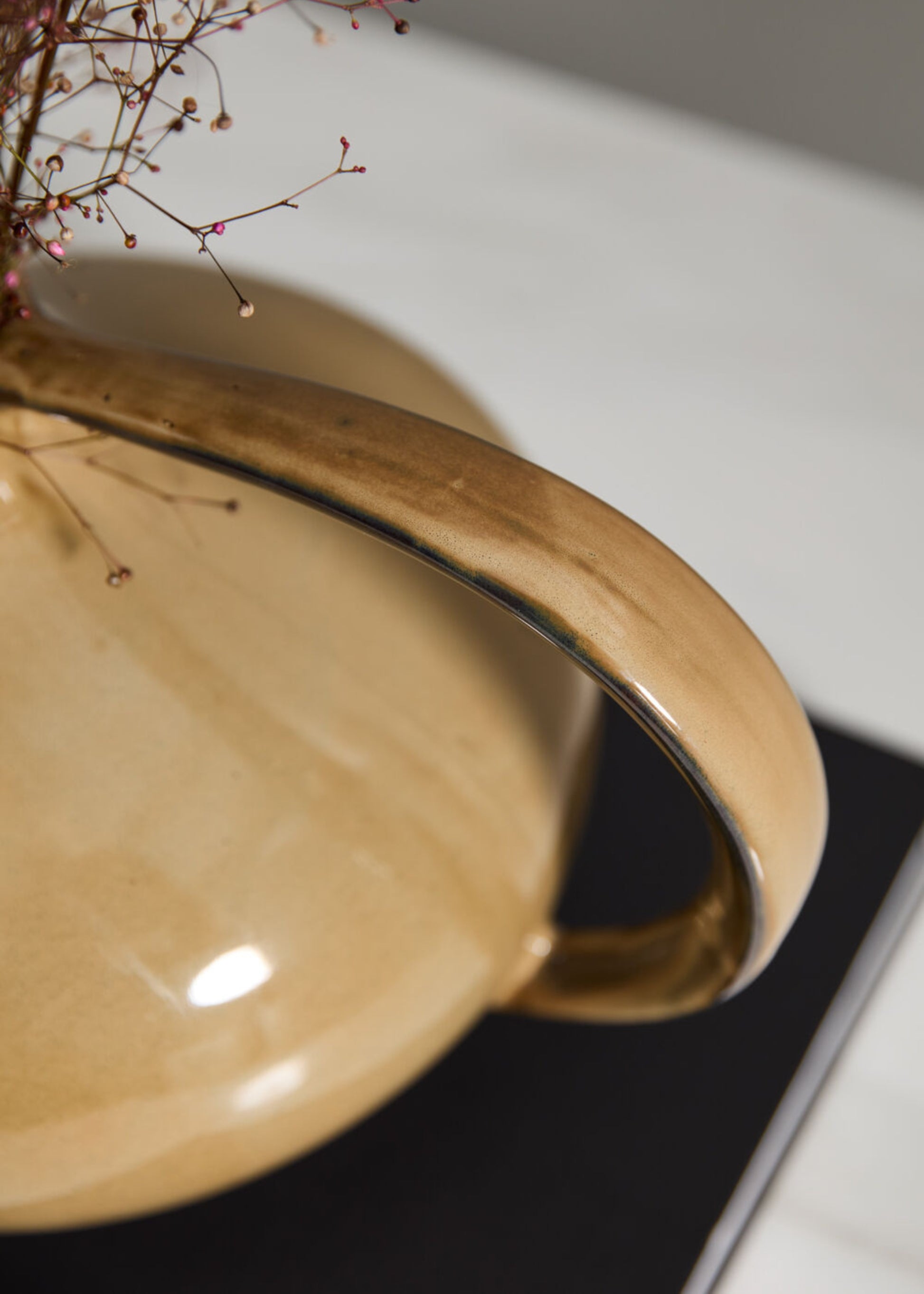 Close-up of a beige ceramic vase handle