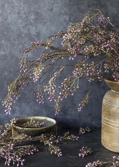 artificial purple berry branches arranged in a vase