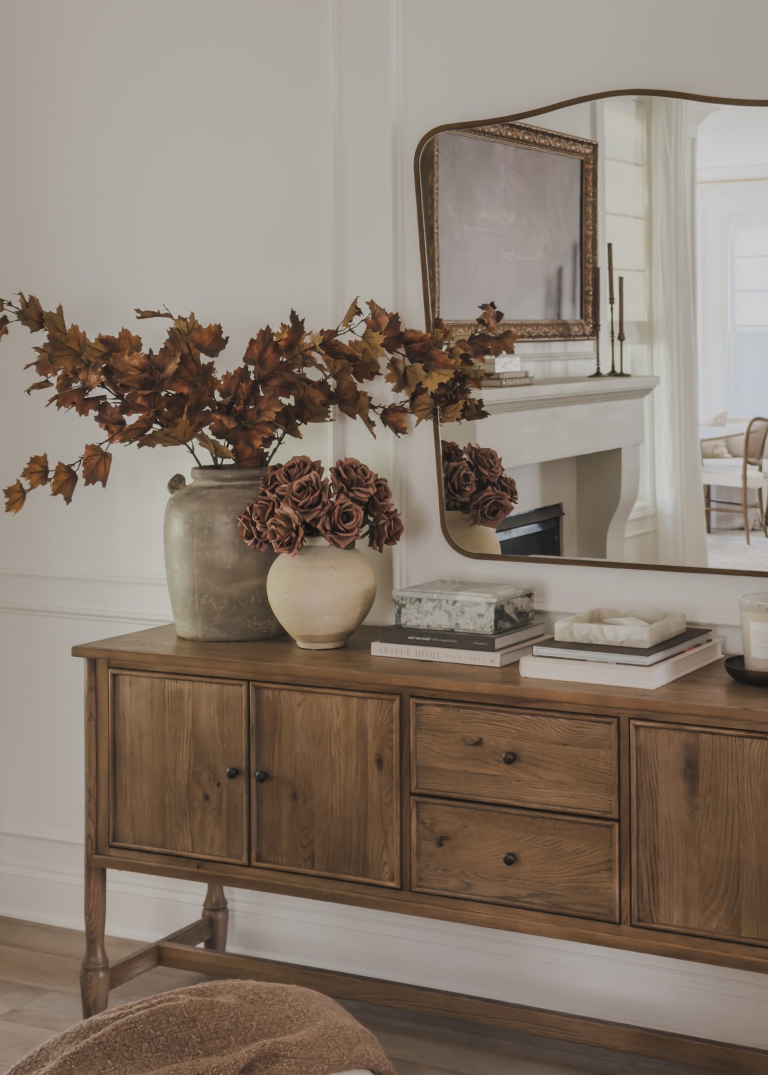 sideboard with decorative vases of real touch roses and maple leaves