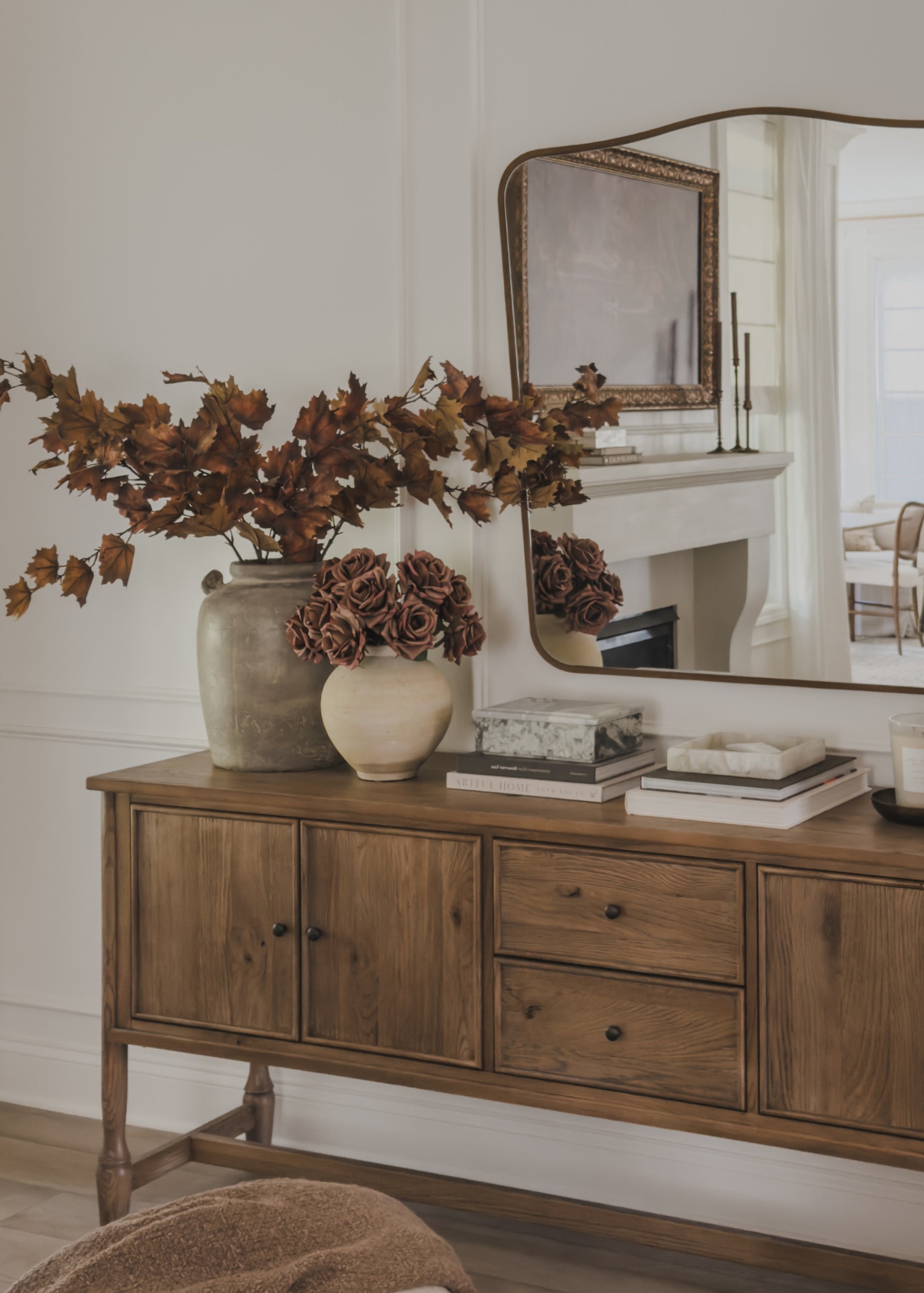sideboard with decorative vases of real touch roses and maple leaves