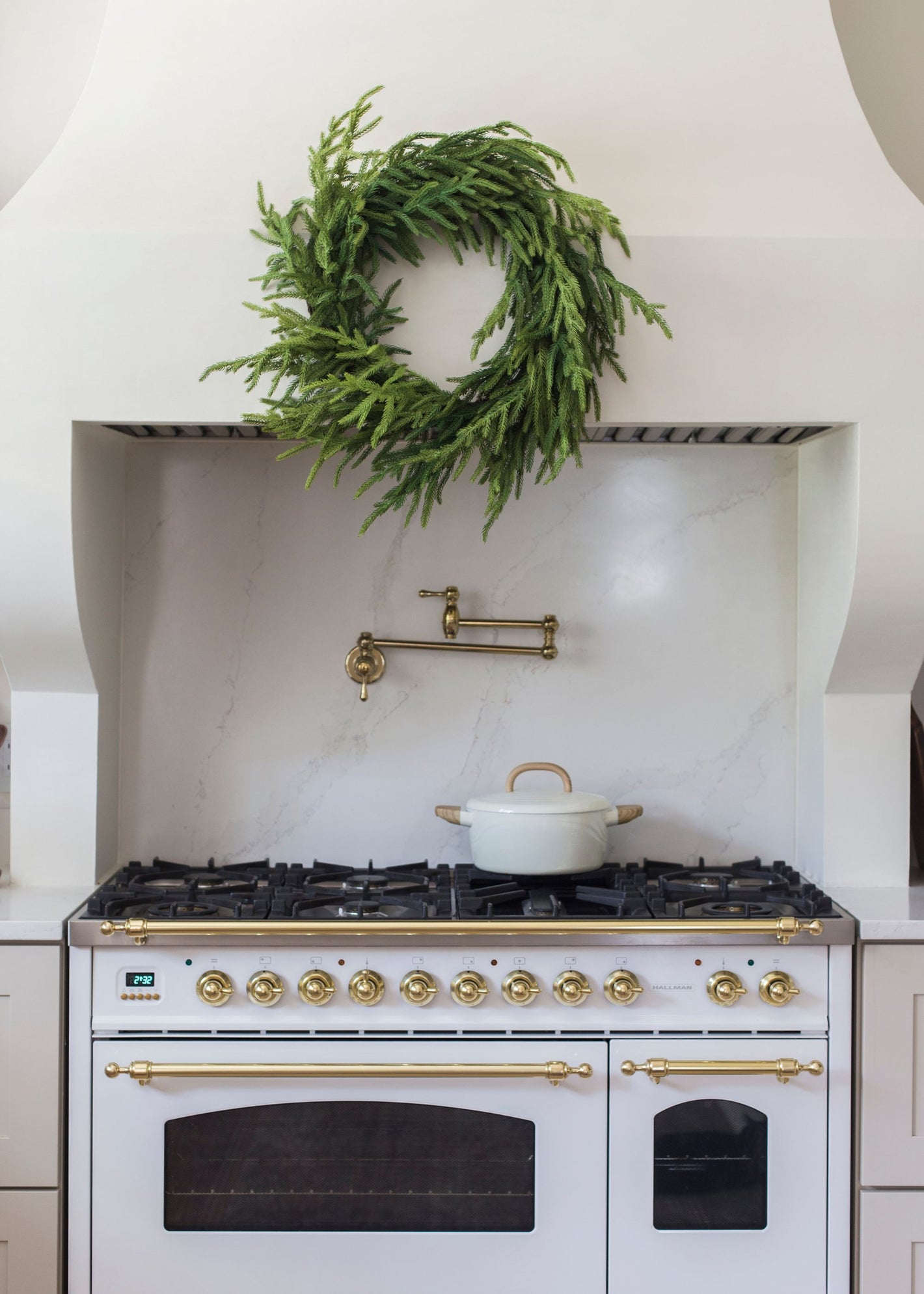 green norfolk pine wreath above white stove