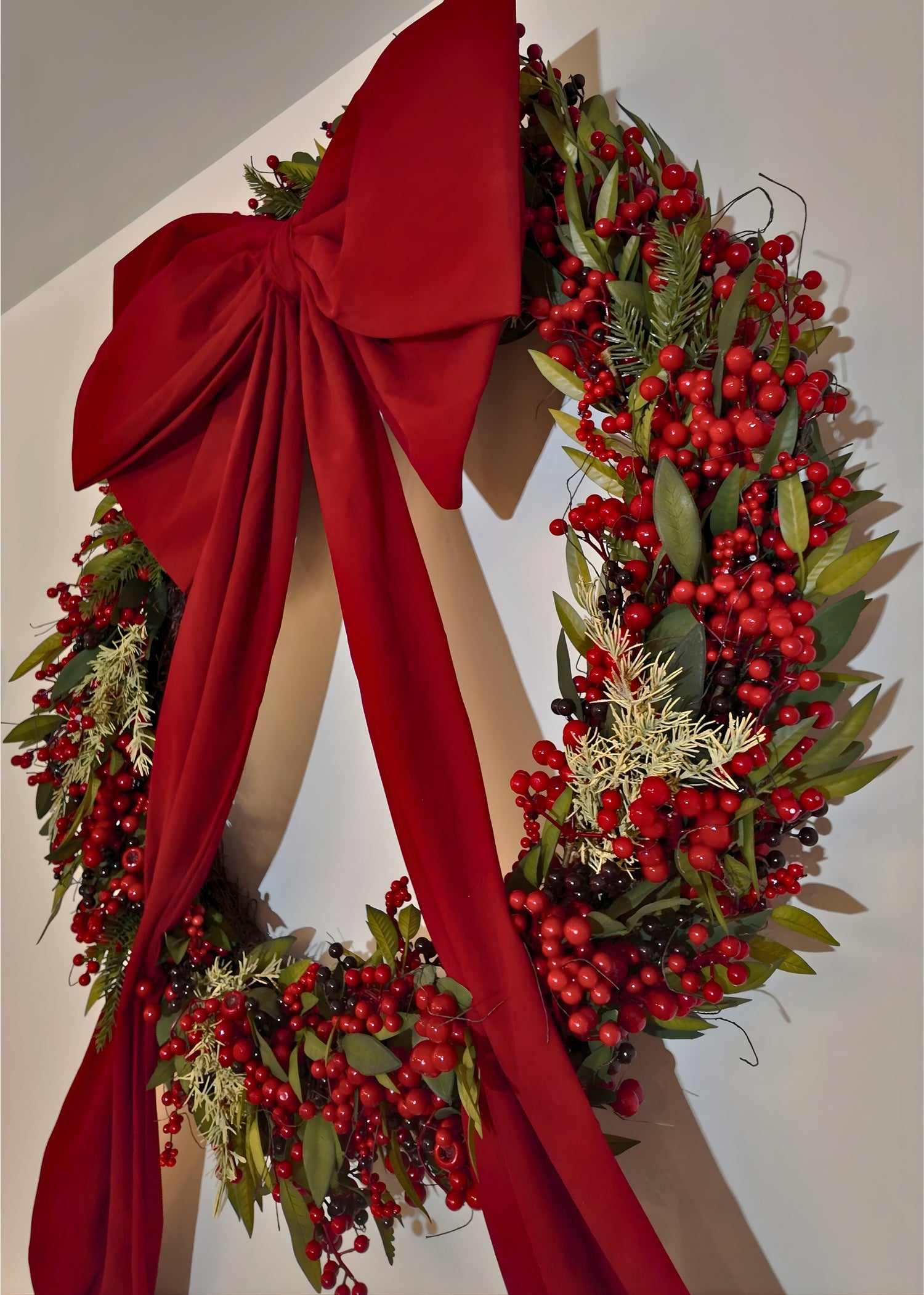 Christmas wreath with red berries and a large red bow 