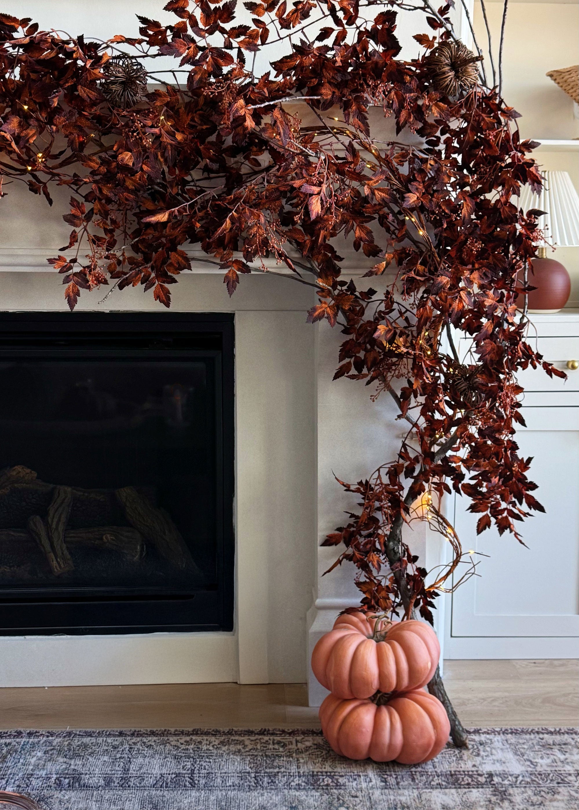 Decorative fall cimicifuga garland with pumpkins on a fireplace mantel.