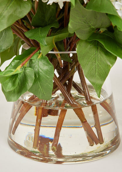 Glass Vase and Acrylic Water of Faux Lilac Arrangement in Afloral Closeup View