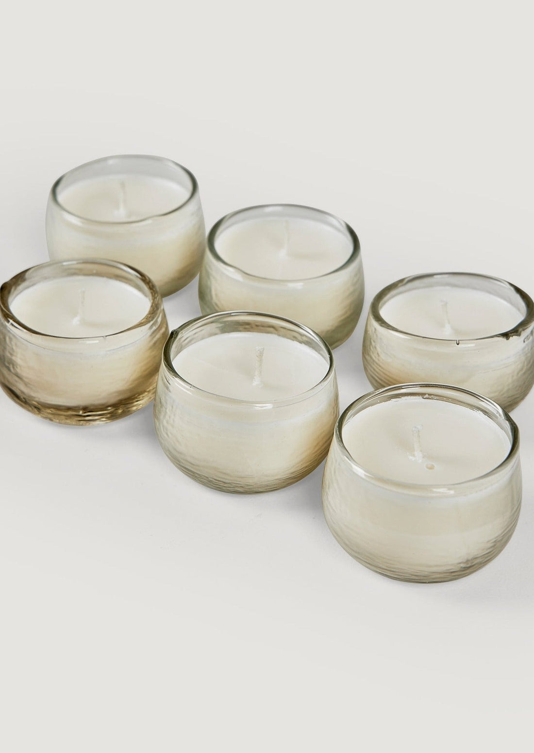 Mini Glass Round Votive Holders Filled with Candles at Afloral