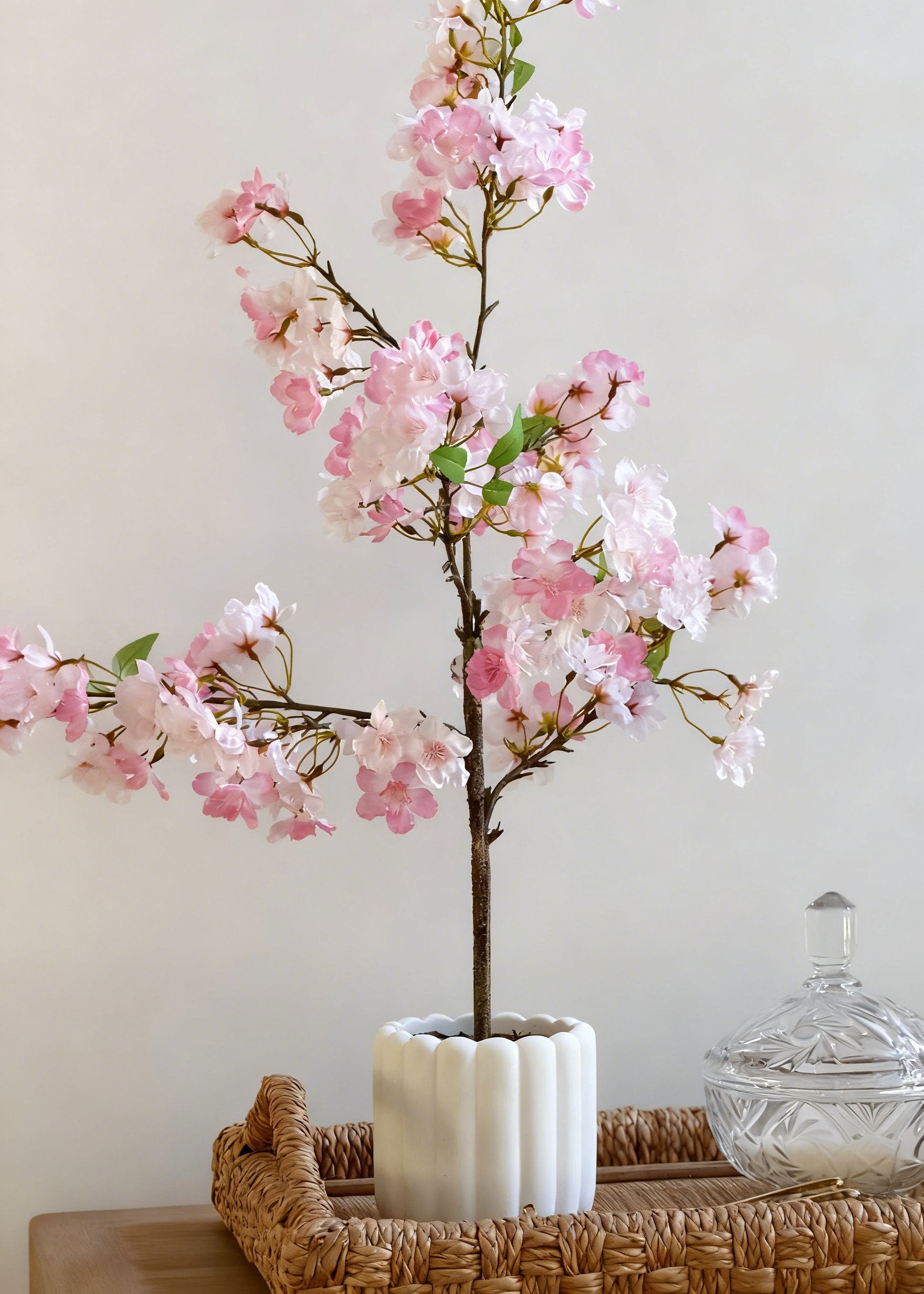 Artificial cherry blossom tree in a white vase 