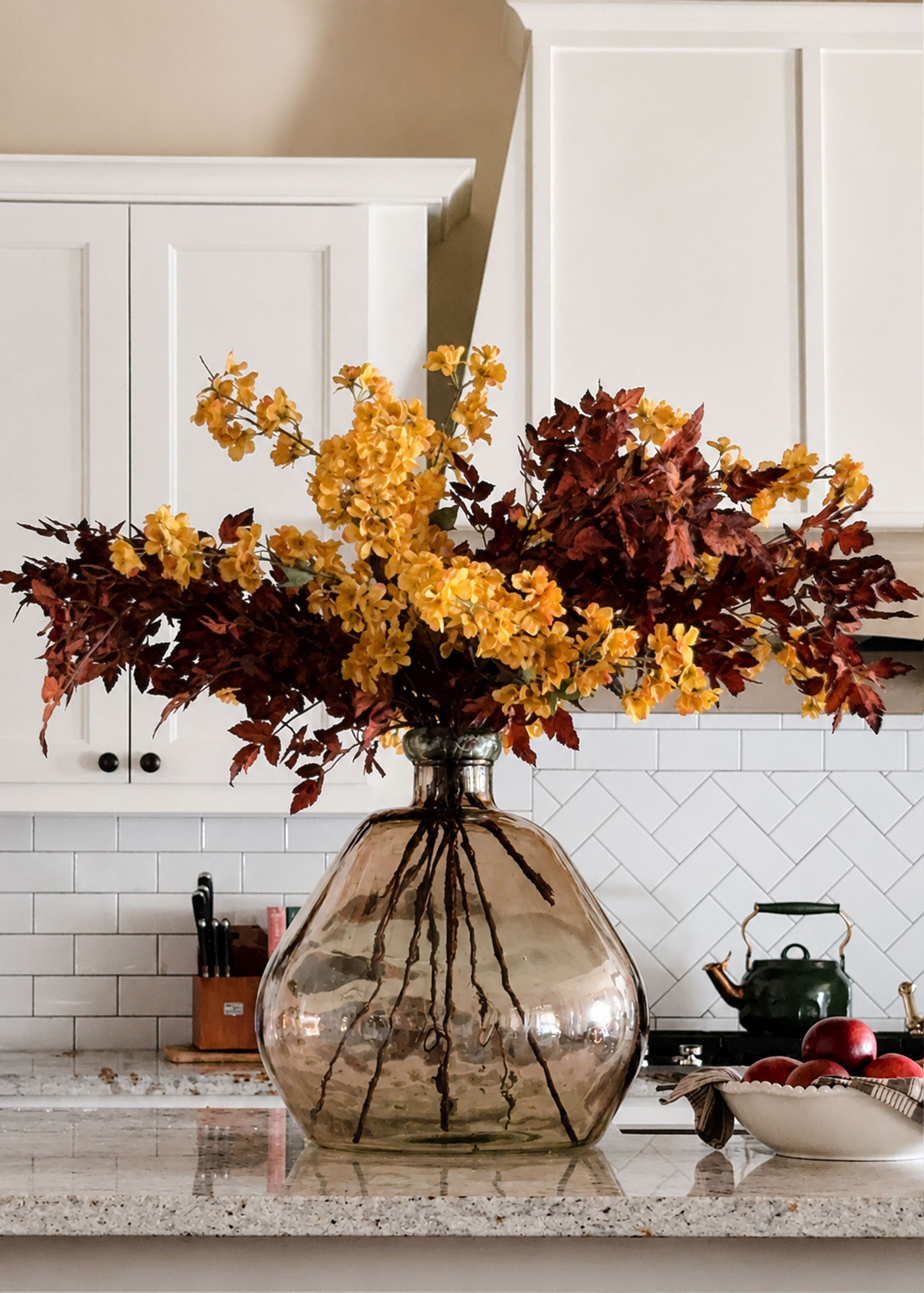 Cherry Blossoms in Fall Yellow and Brown Cimicifuga Leaves Arranged in a vase in a Kitchen