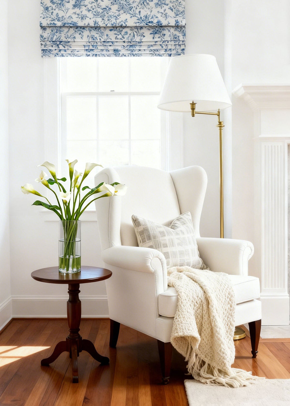 White armchair with side table featuring a faux calla lily arrangement in white
