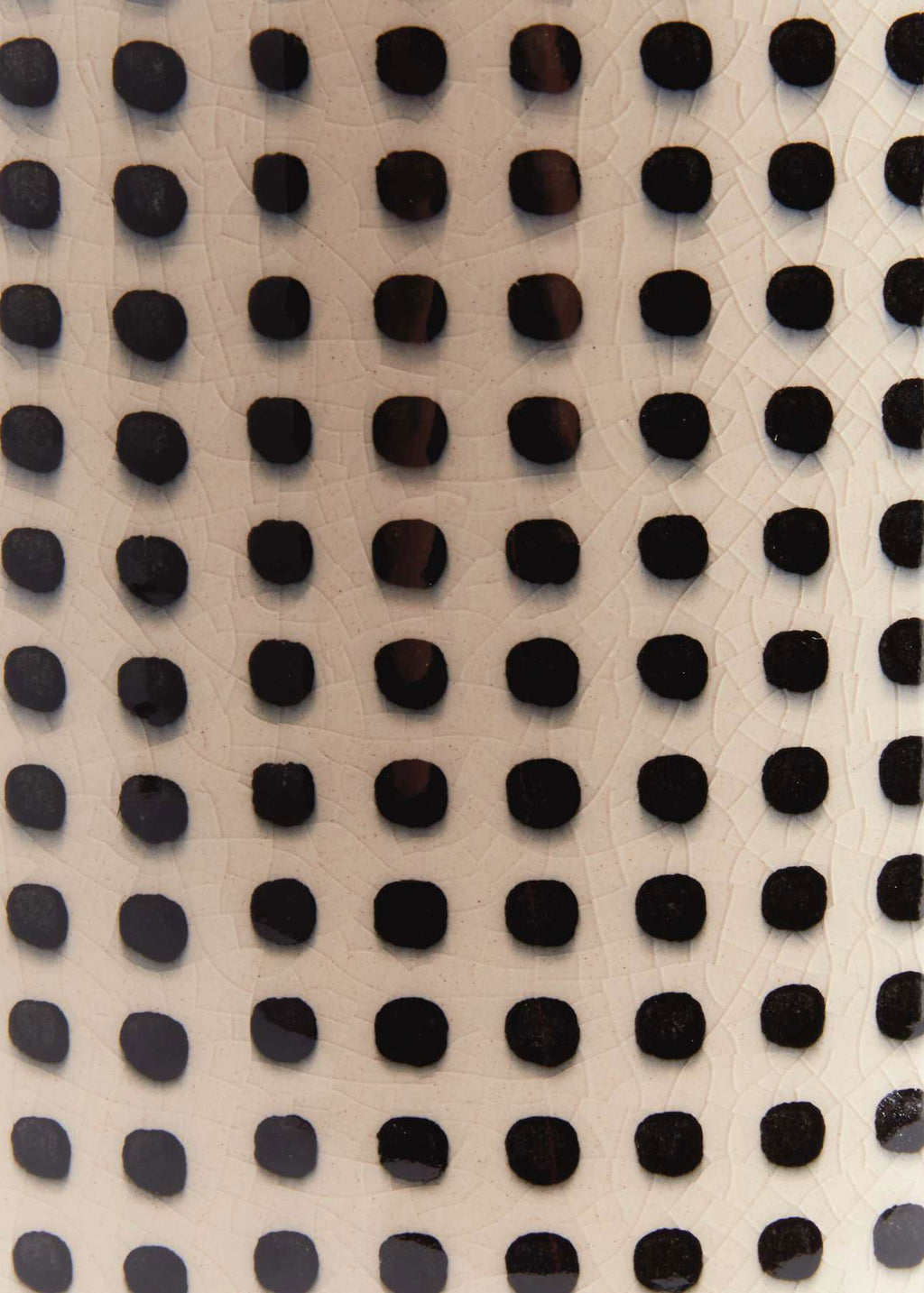 Close-up of a textured ceramic surface with black dots