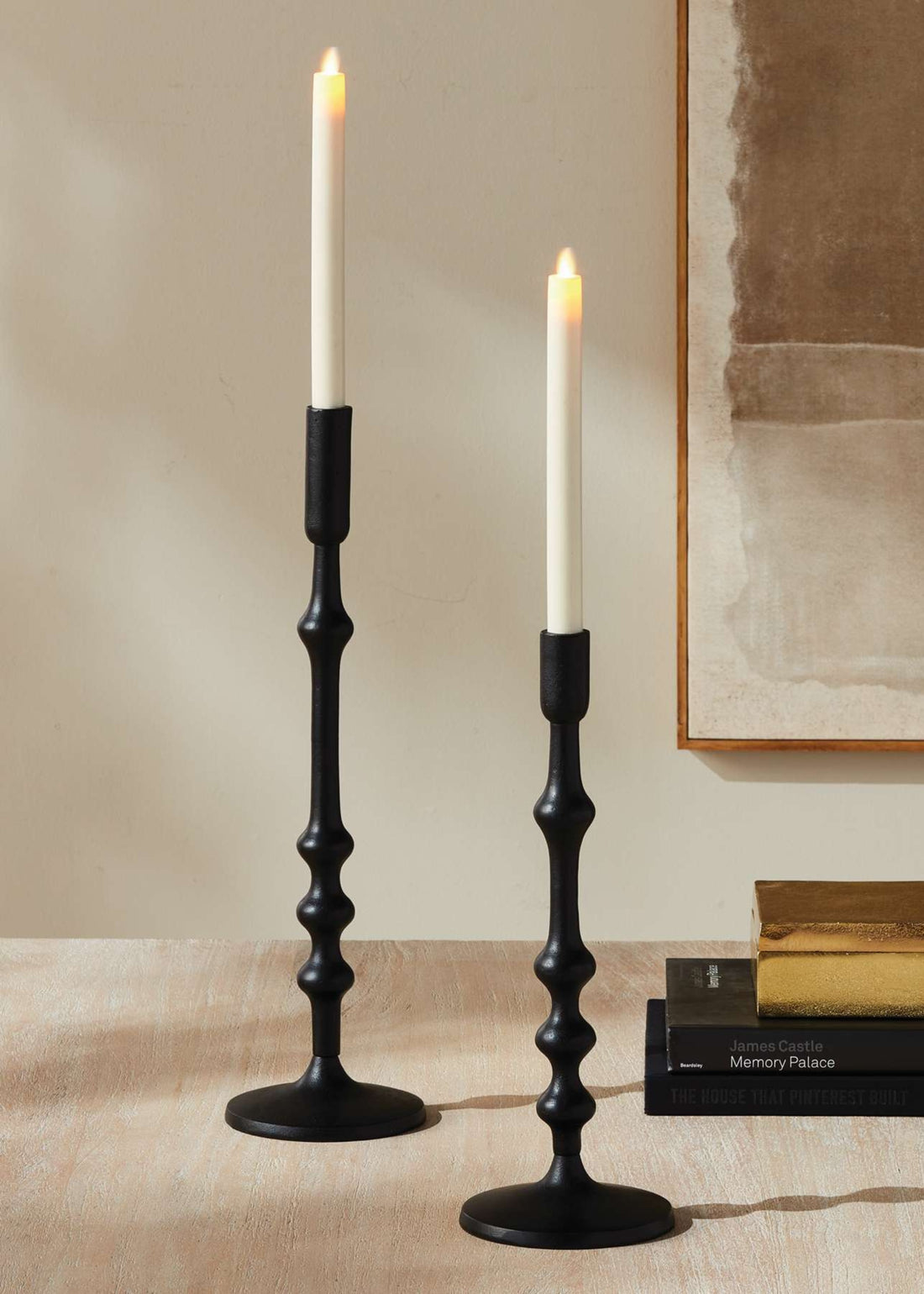 Two black candlesticks with lit candles