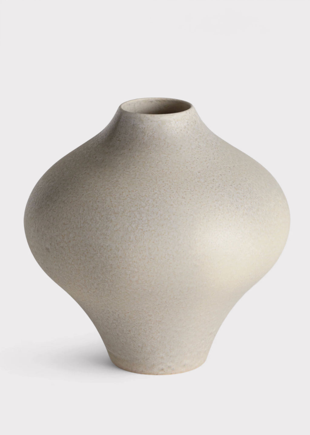 A minimalist ceramic vase with a textured, speckled finish in a light beige-gray color, featuring a bulbous body and a narrow neck, set against a plain white background.