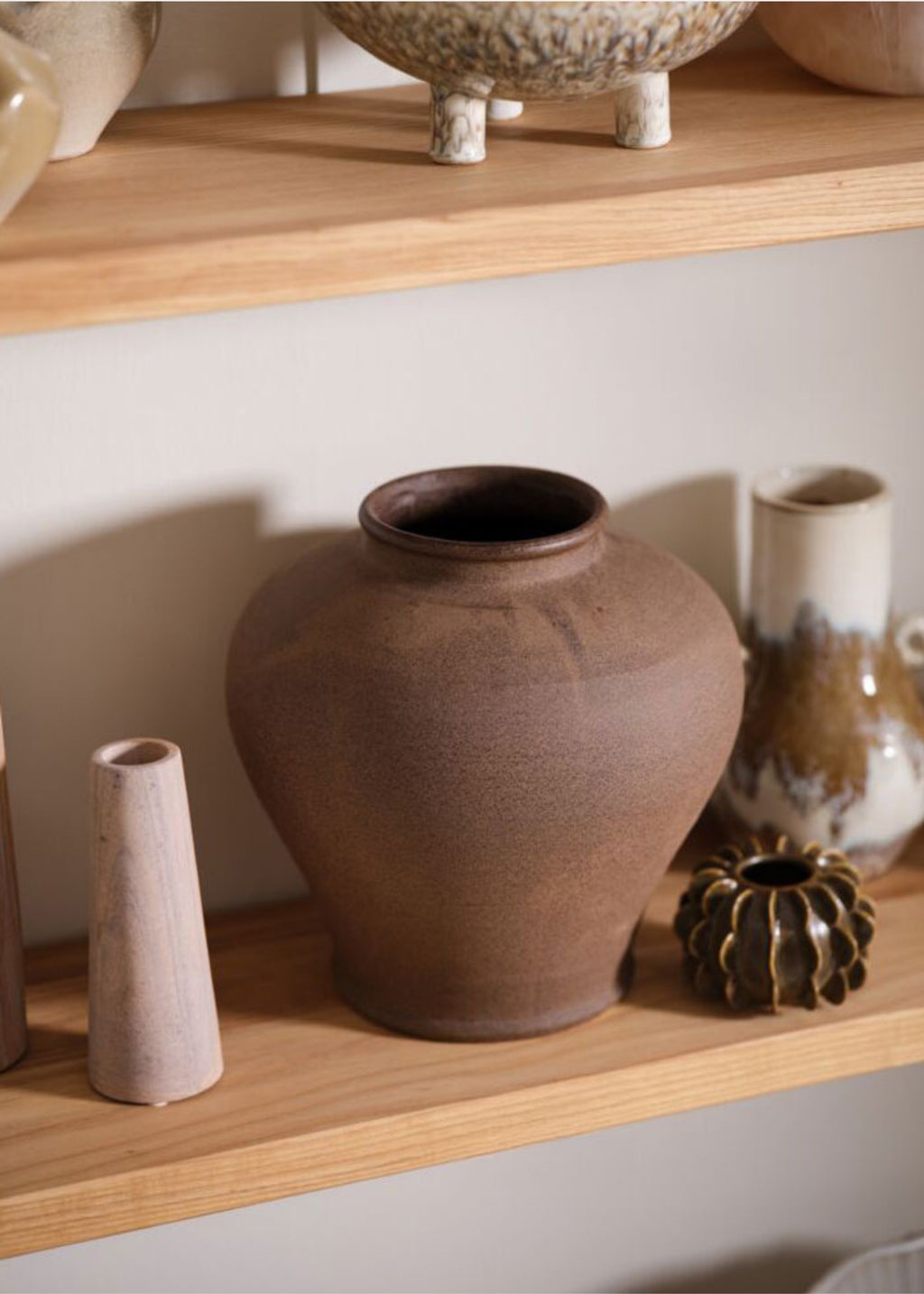 Collection of ceramic vases on a wooden shelf