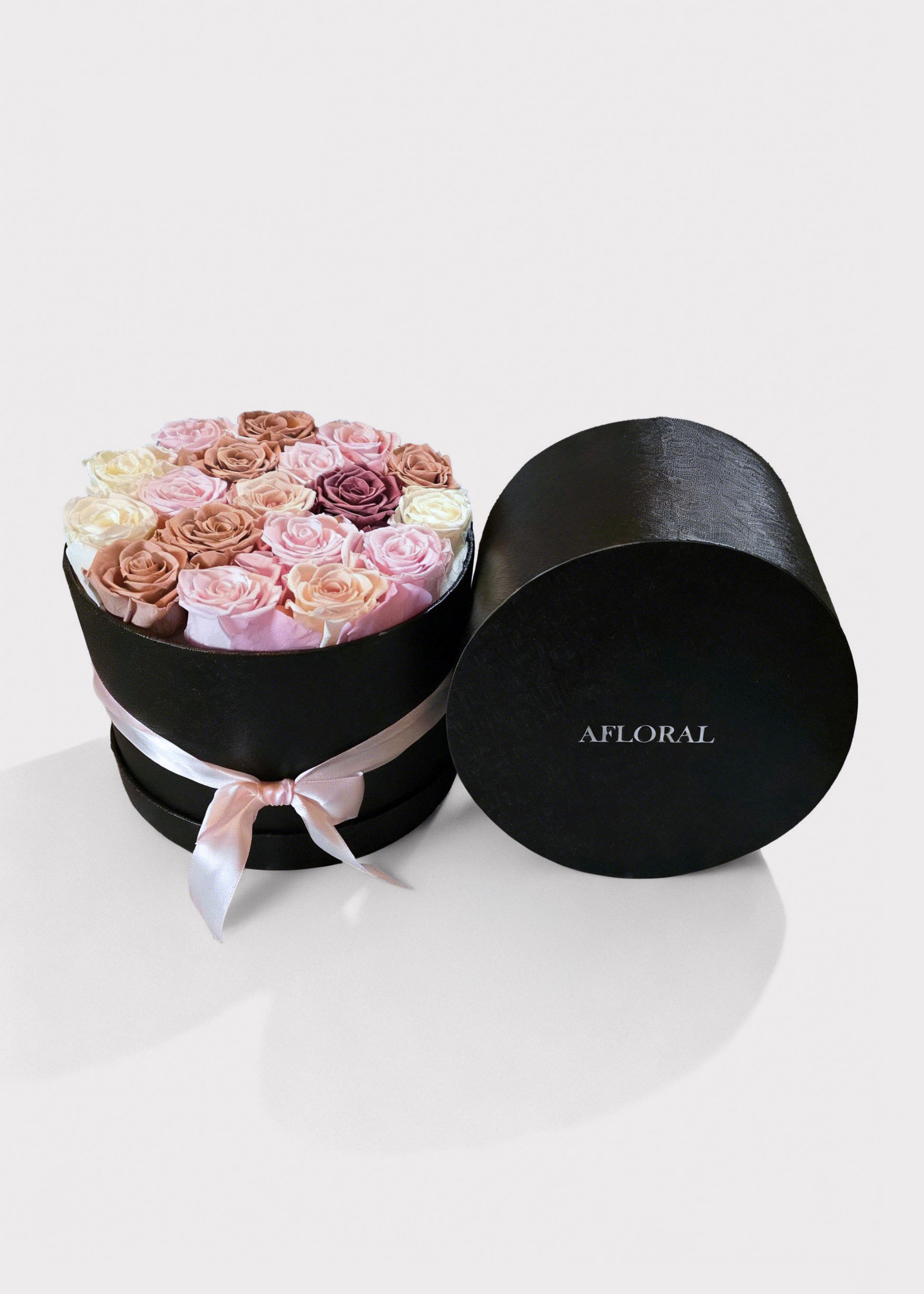 Round black box with a bouquet of preserved roses and 'Afloral' branding 