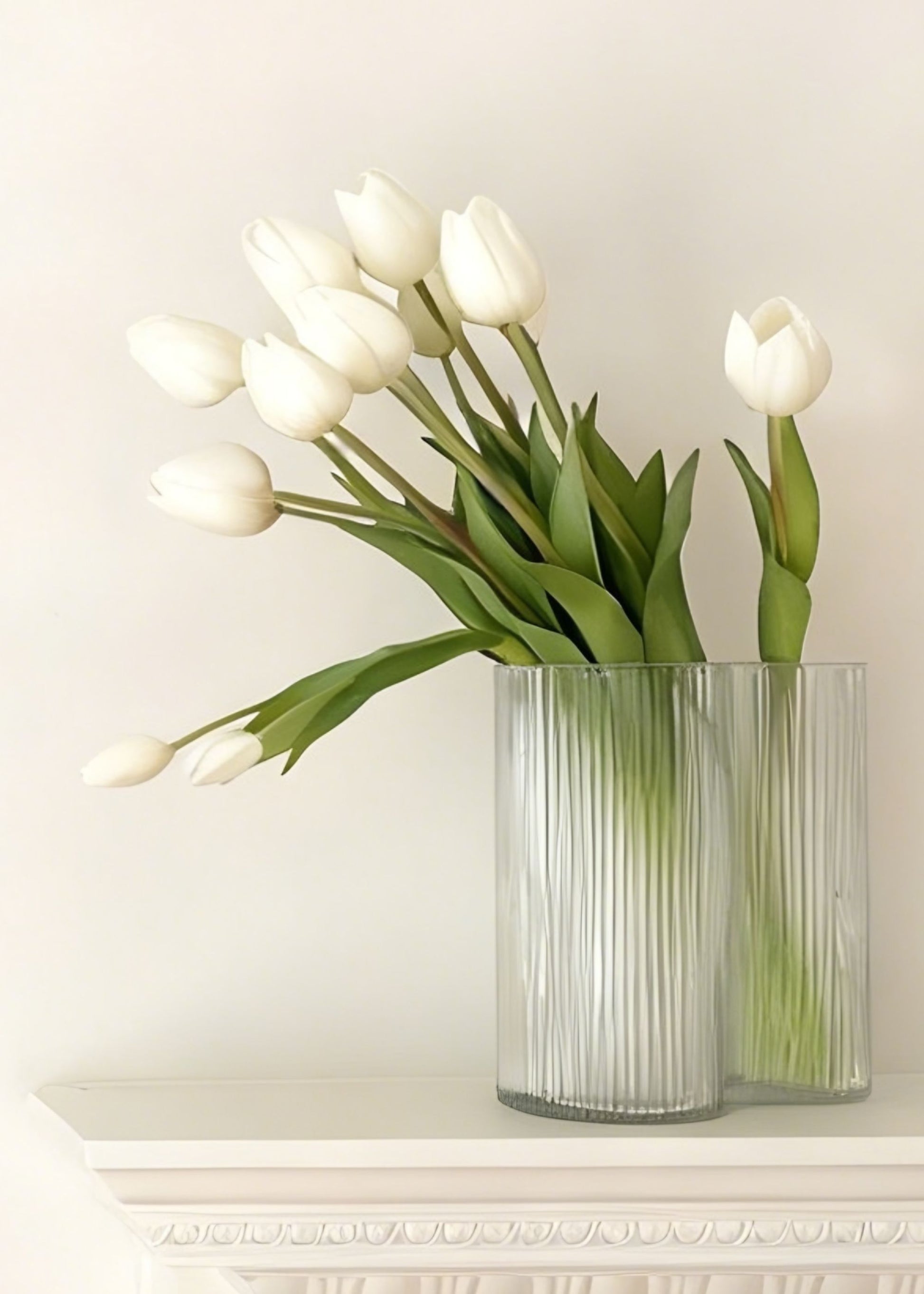 Clear glass vase with white tulips