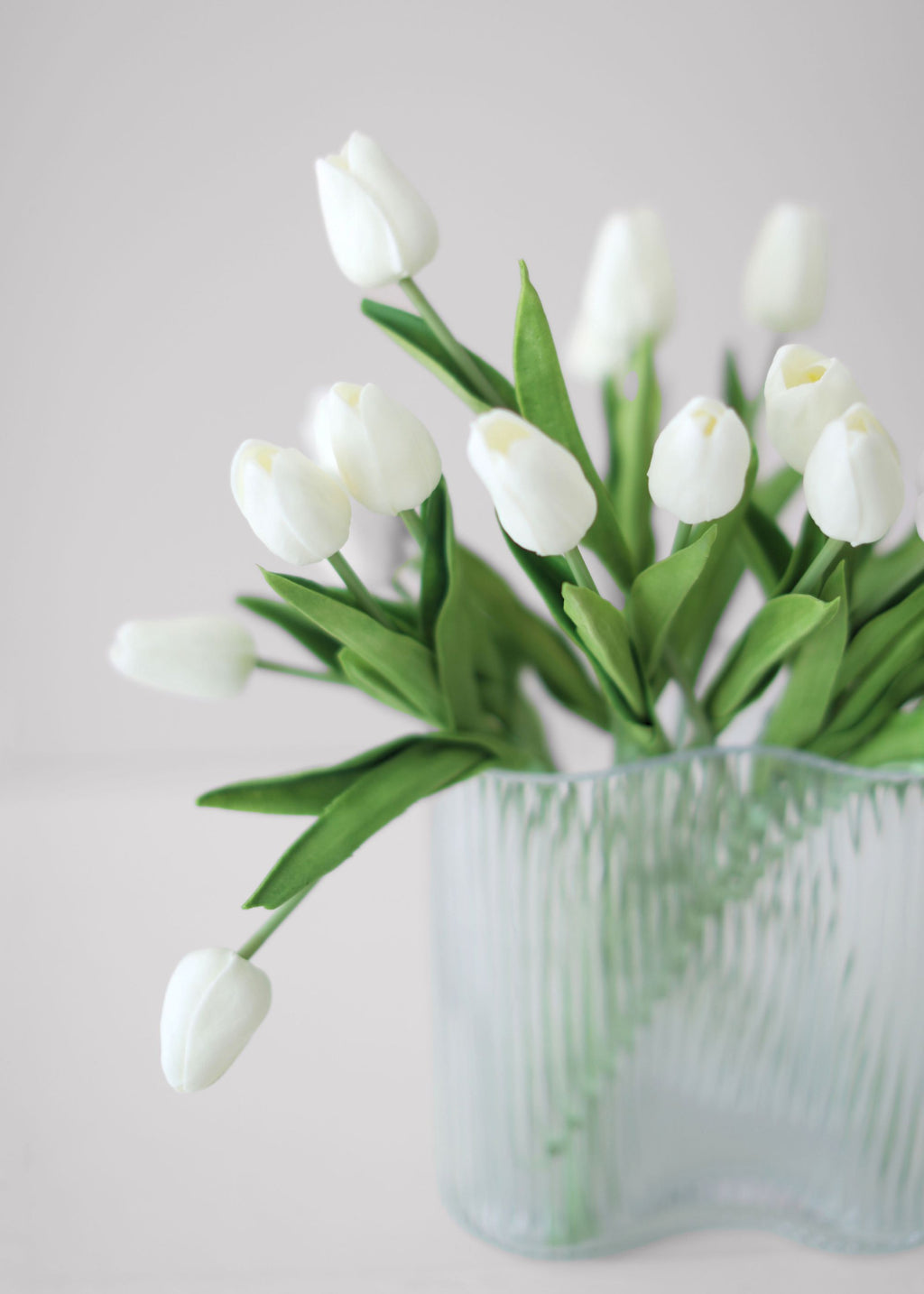 Clear glass vase with white tulips 