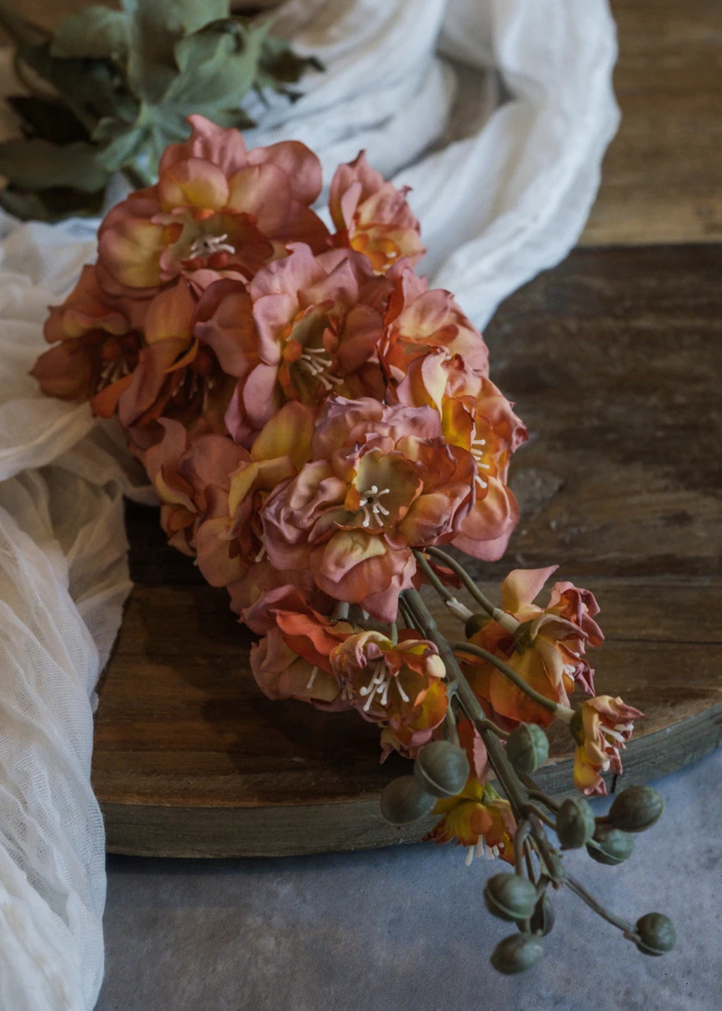 Close-up of a Dried Look Artificial Larkspur Flower in Orange and Pink 