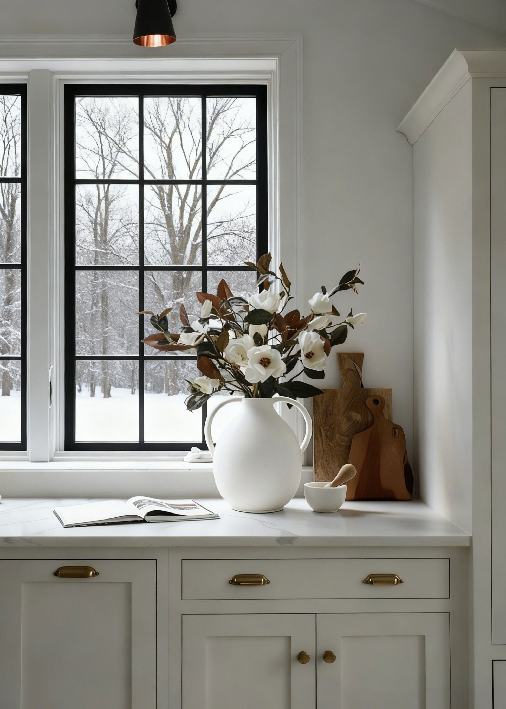 Magnolia flowers and branches arranged in the Afloral jug vase