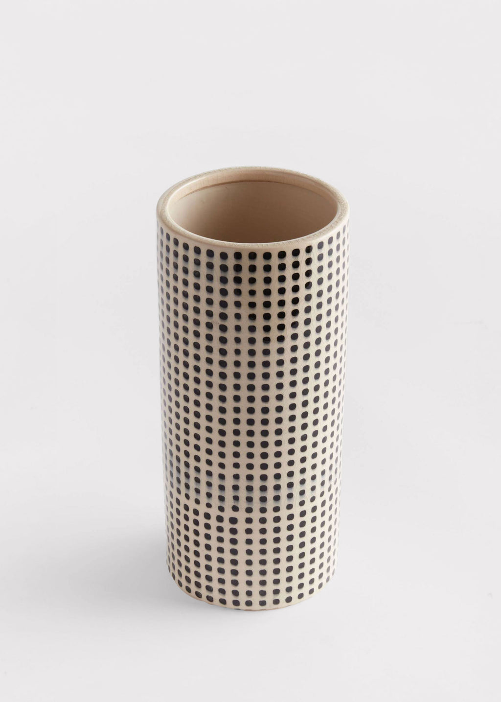 Cylindrical ceramic vase with a black dot pattern