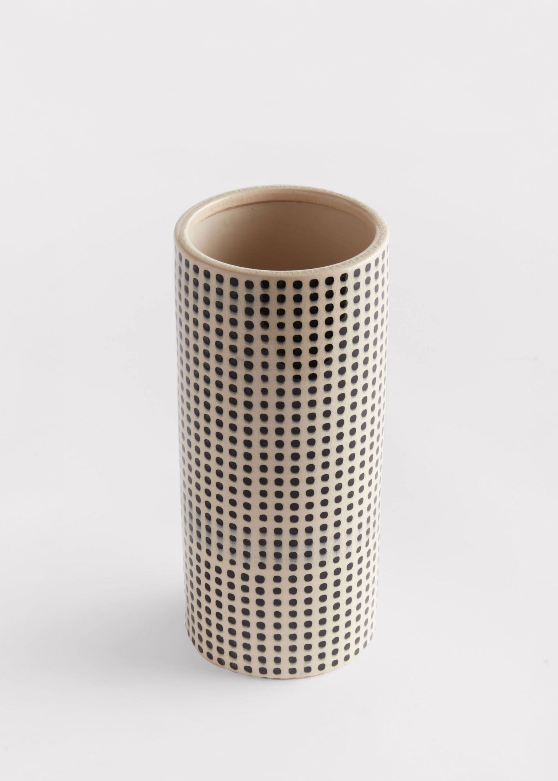 Cylindrical ceramic vase with a black dot pattern