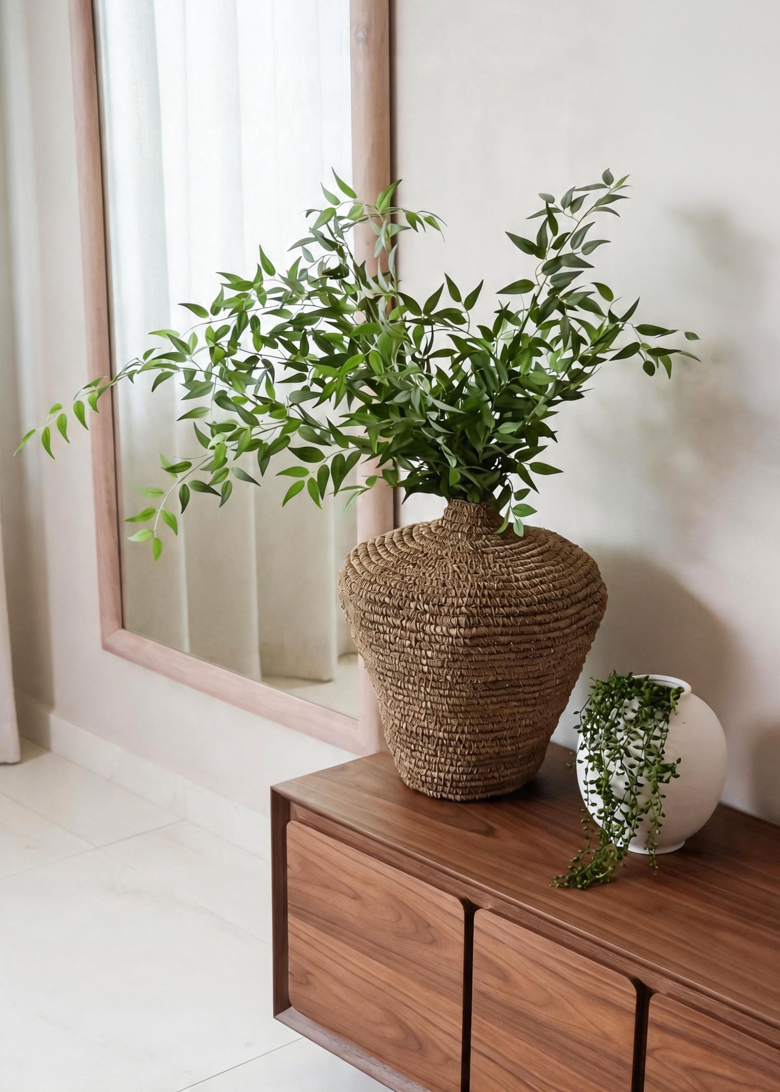 Artificial Ruscus and String of Pearl Arranged on a Credenza