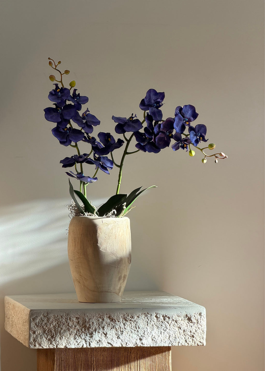 blue orchids styled in a wooden vase