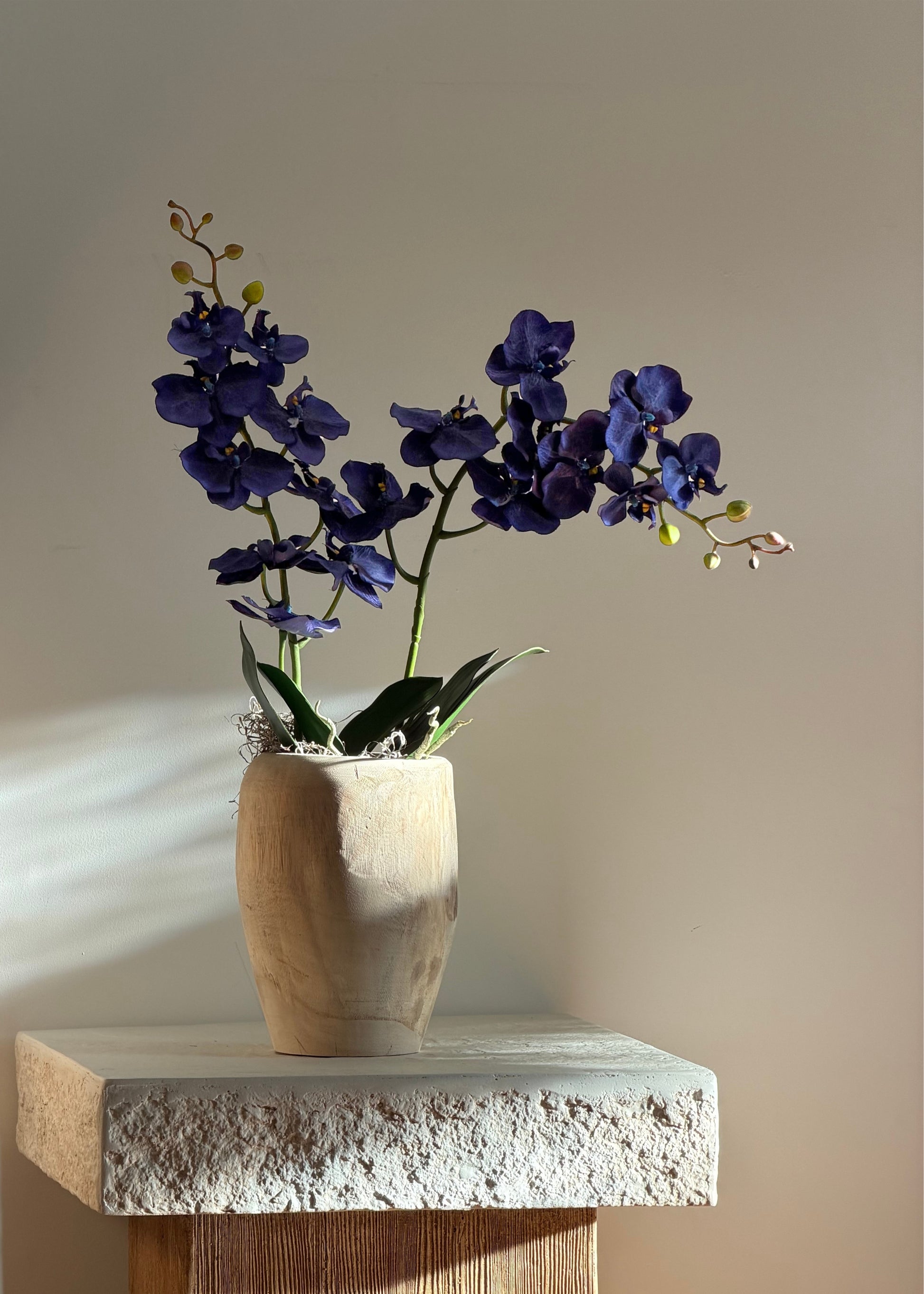blue orchids styled in a wooden vase