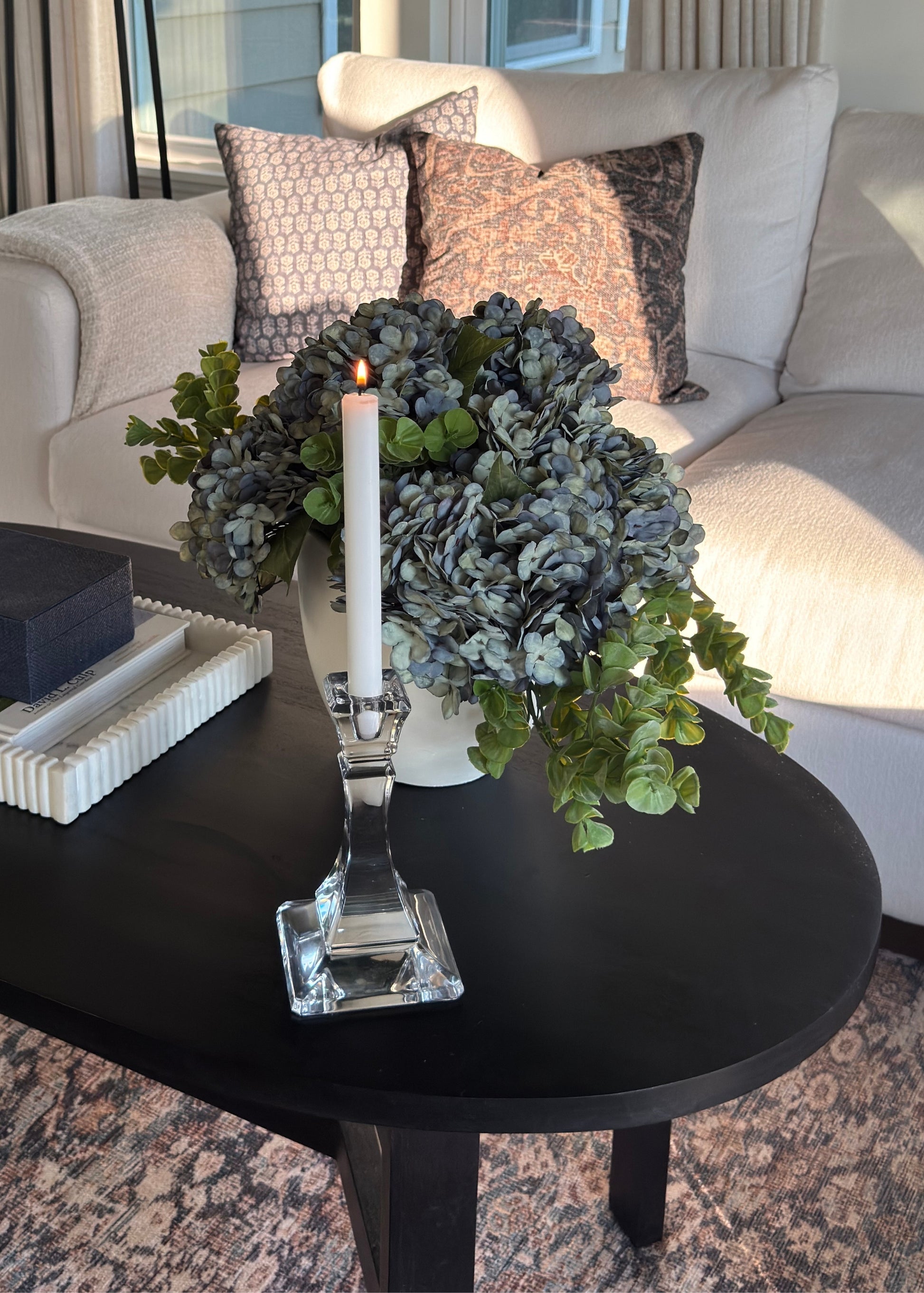 Blue hydrangea and eucalyptus artificial flower arrangement on a coffee table