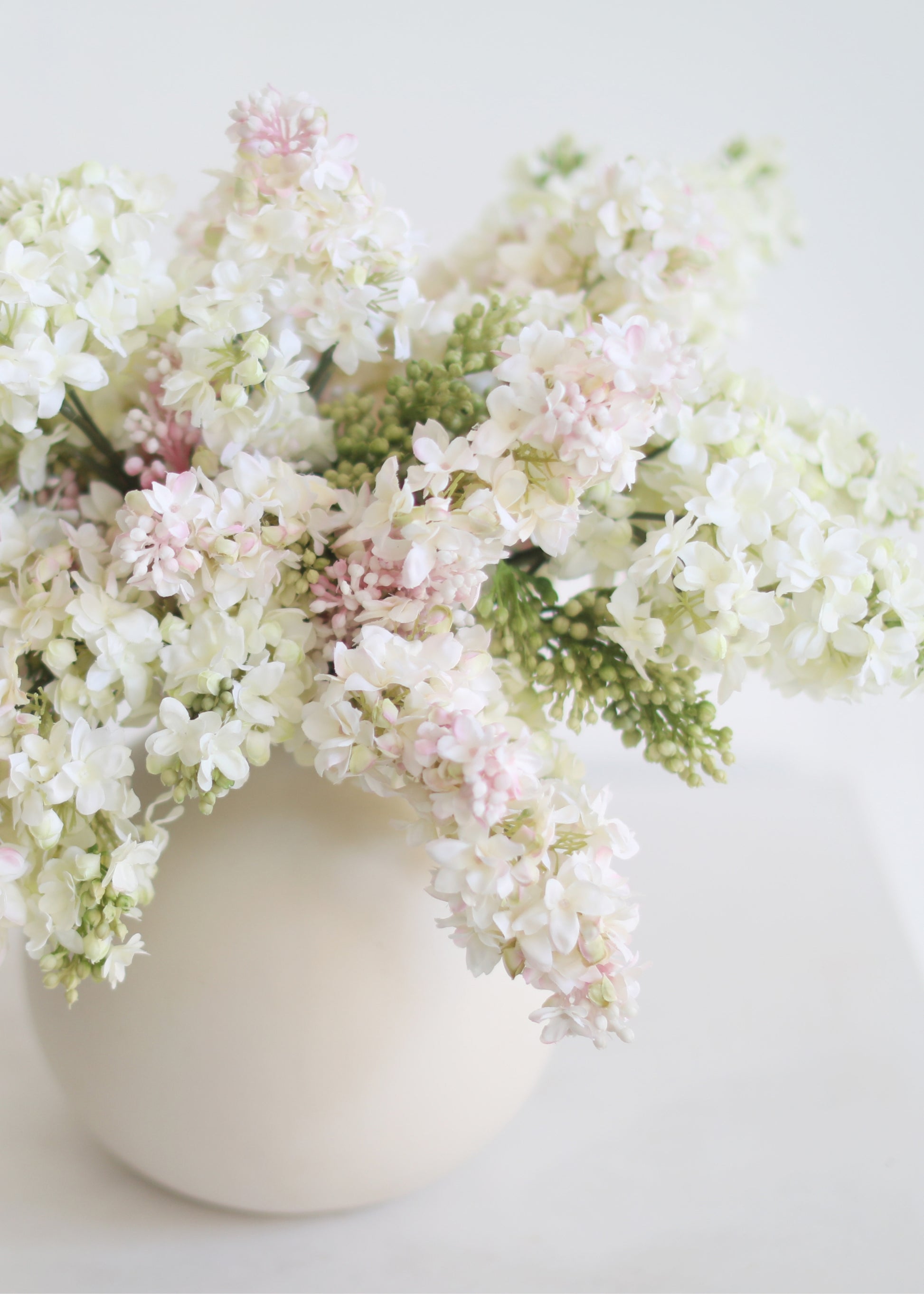 arrangement of faux cream and pink lilacs