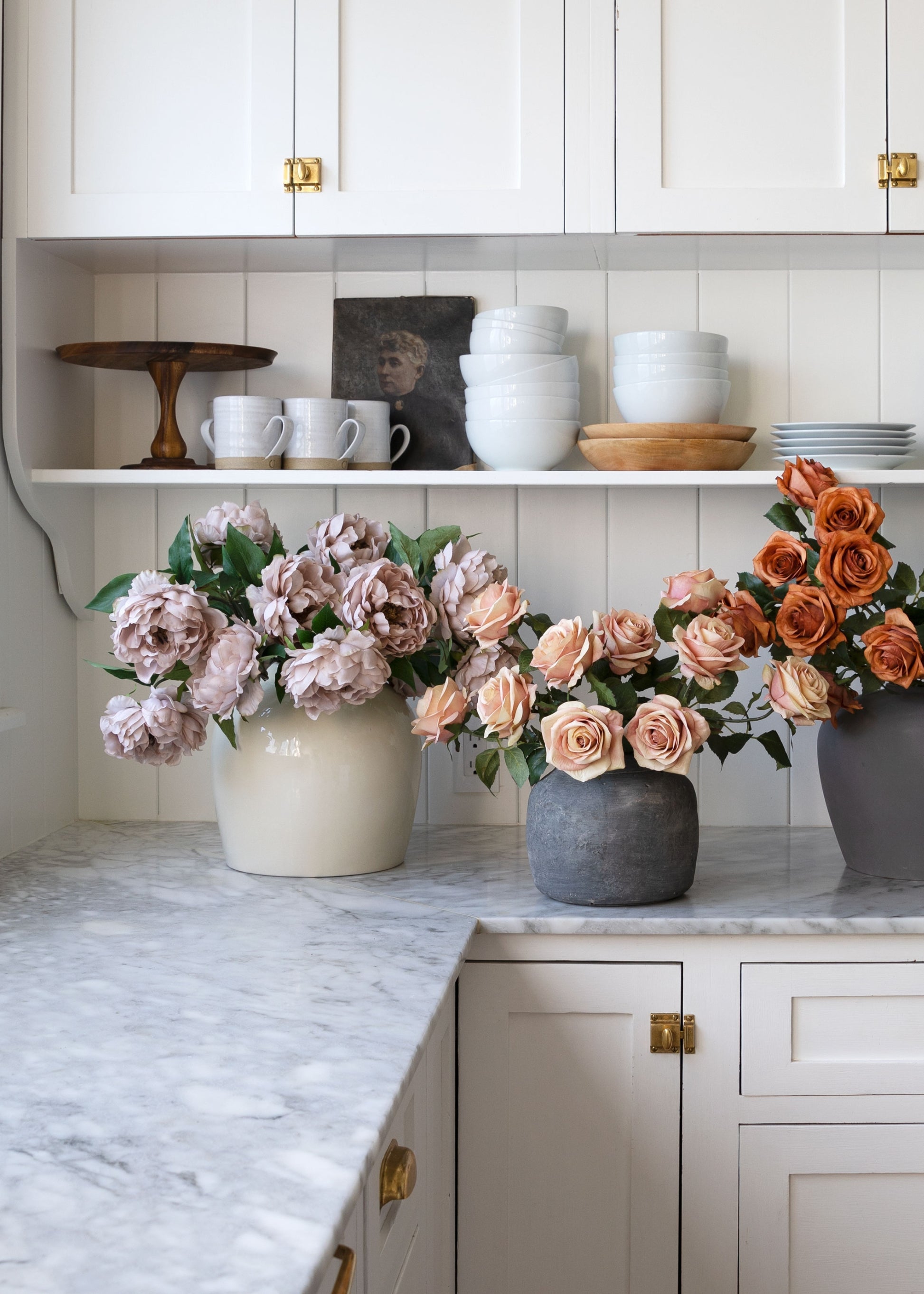 Decorative faux flowers in vases on a kitchen counter 