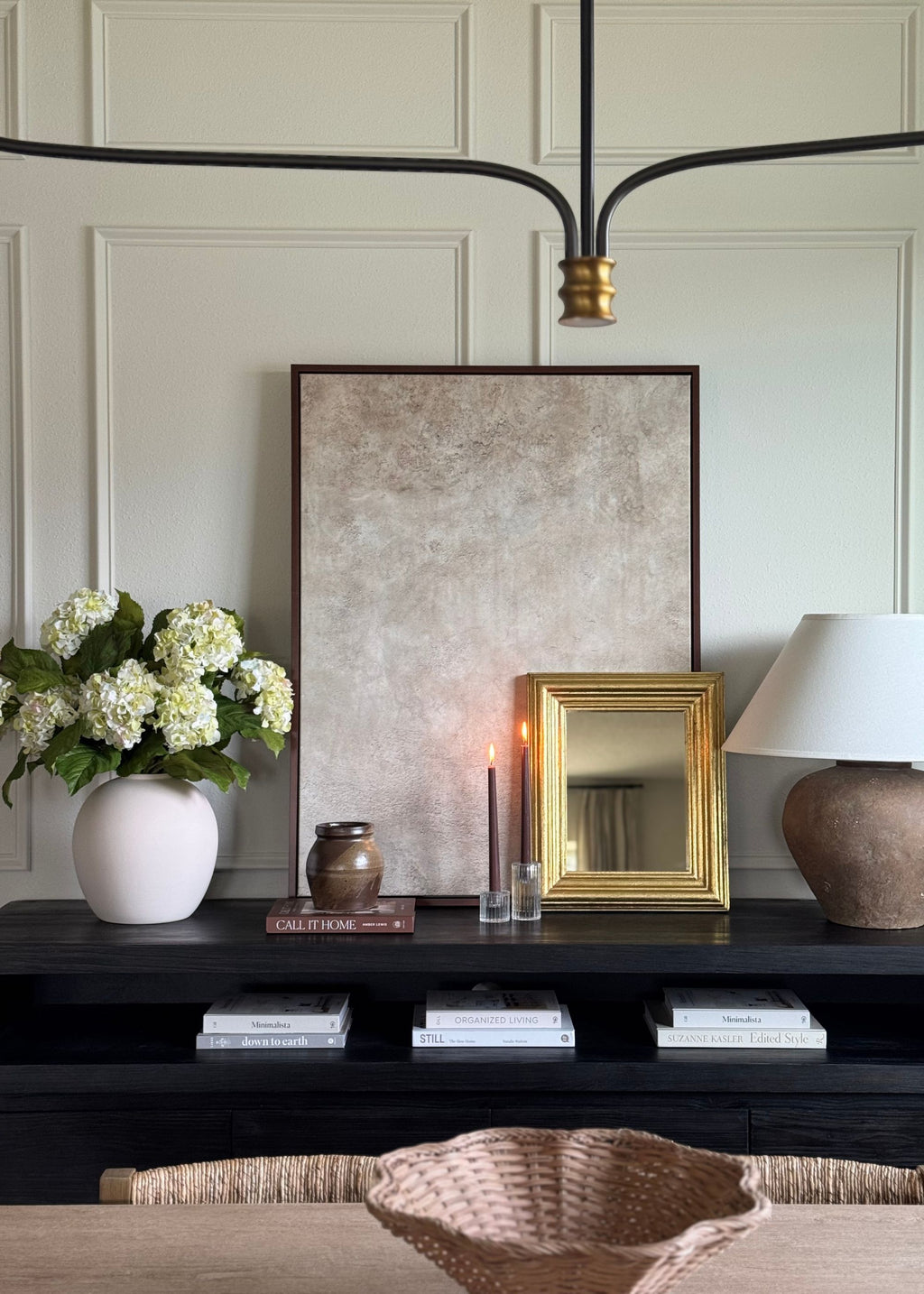 Decorative console table with a vase of cream green faux hydrangeas