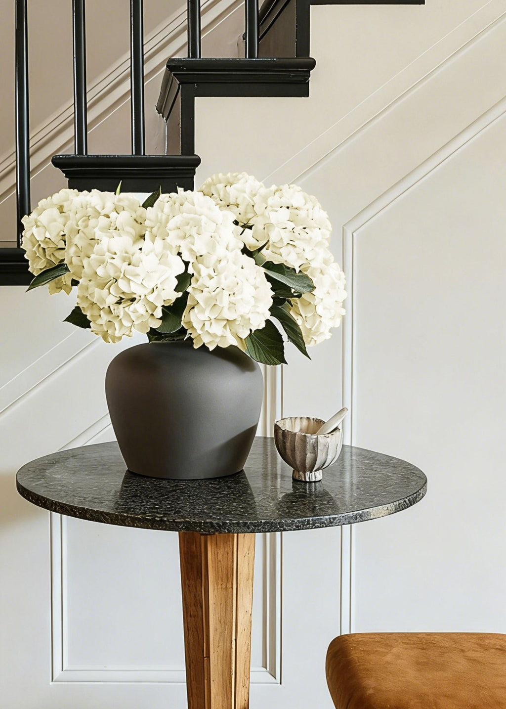 Dark gray vase with white hydrangea flowers