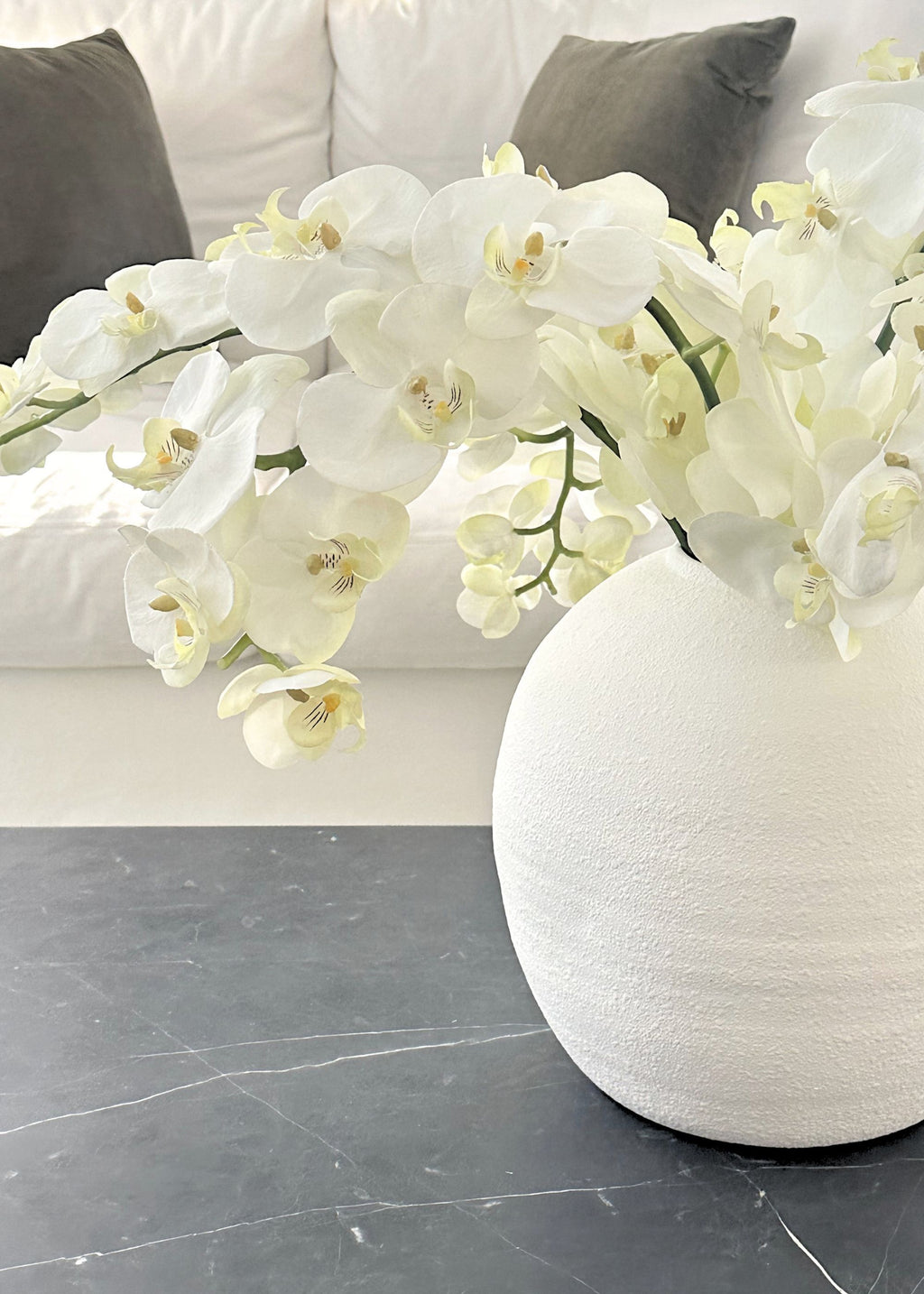White flowers in a vase against a neutral background