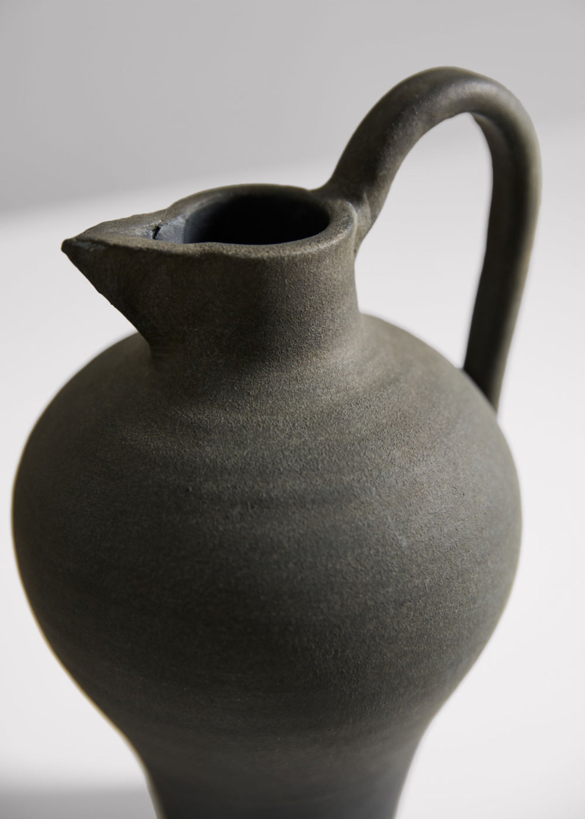 close-up of a dark gray ceramic pitcher 