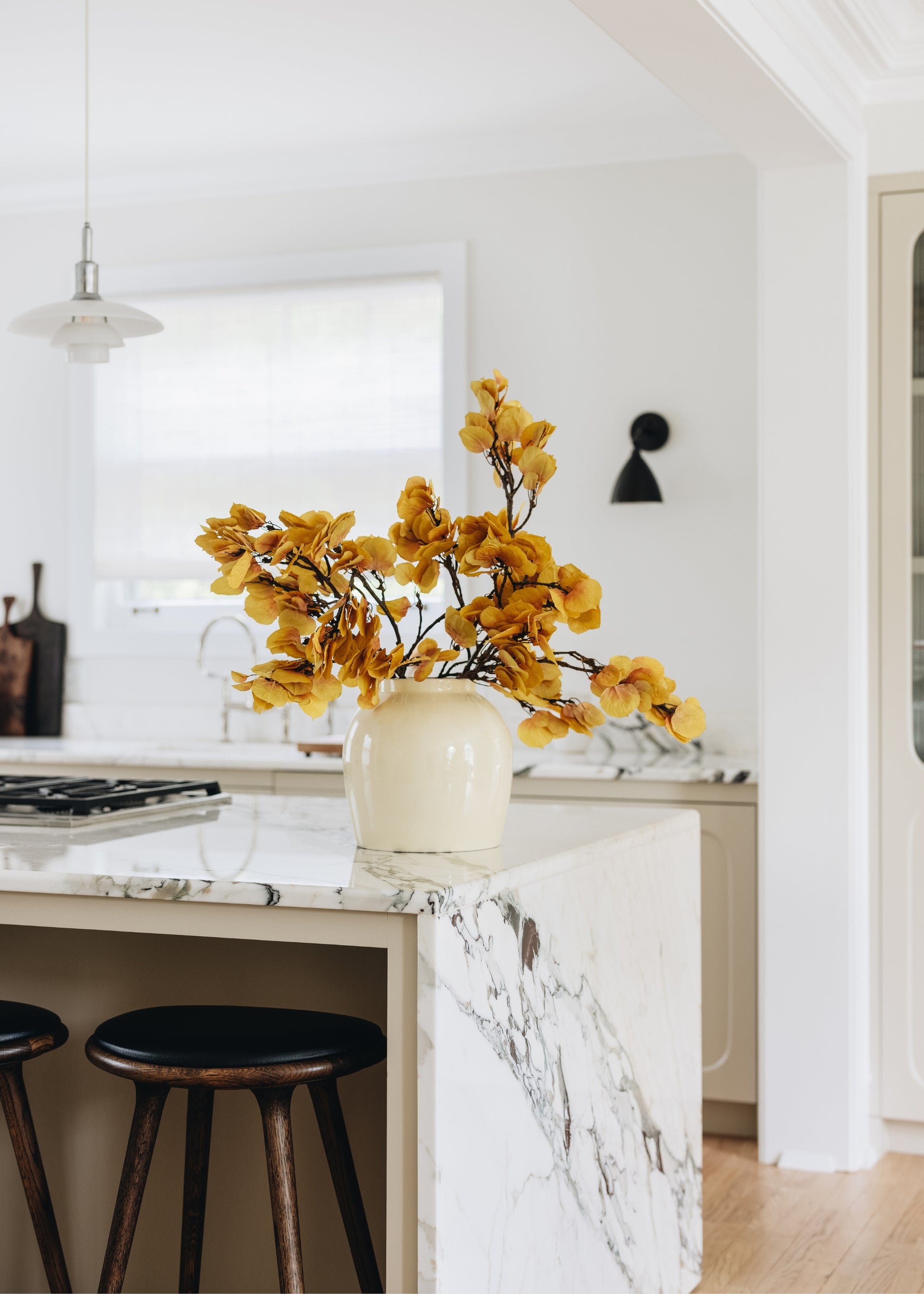Yellow aspen leaves in a vase on a marble kitchen island 