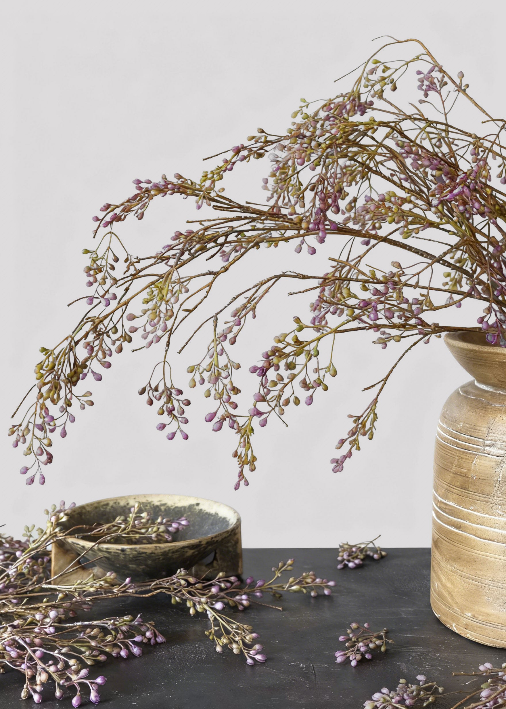 artificial purple berry branches arranged in a vase