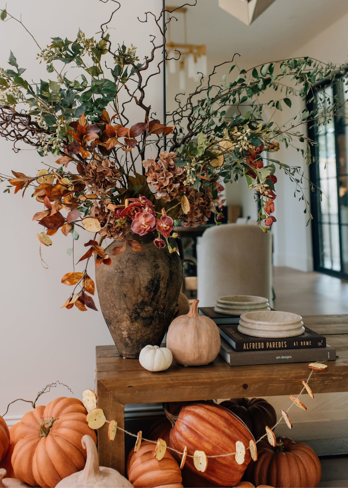fall flower arrangement with pumpkins and a faux apple garland