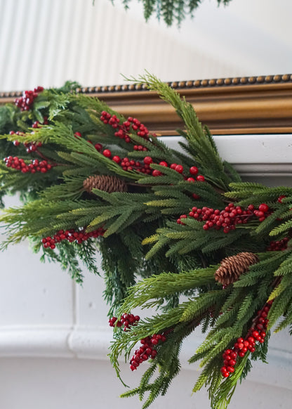 Close-up of pine and red berry stems in garland