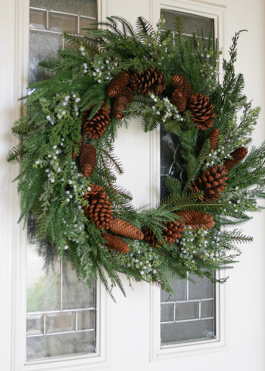 Fake Winter Greenery Wreath with Berries and Pine Cones on White Door