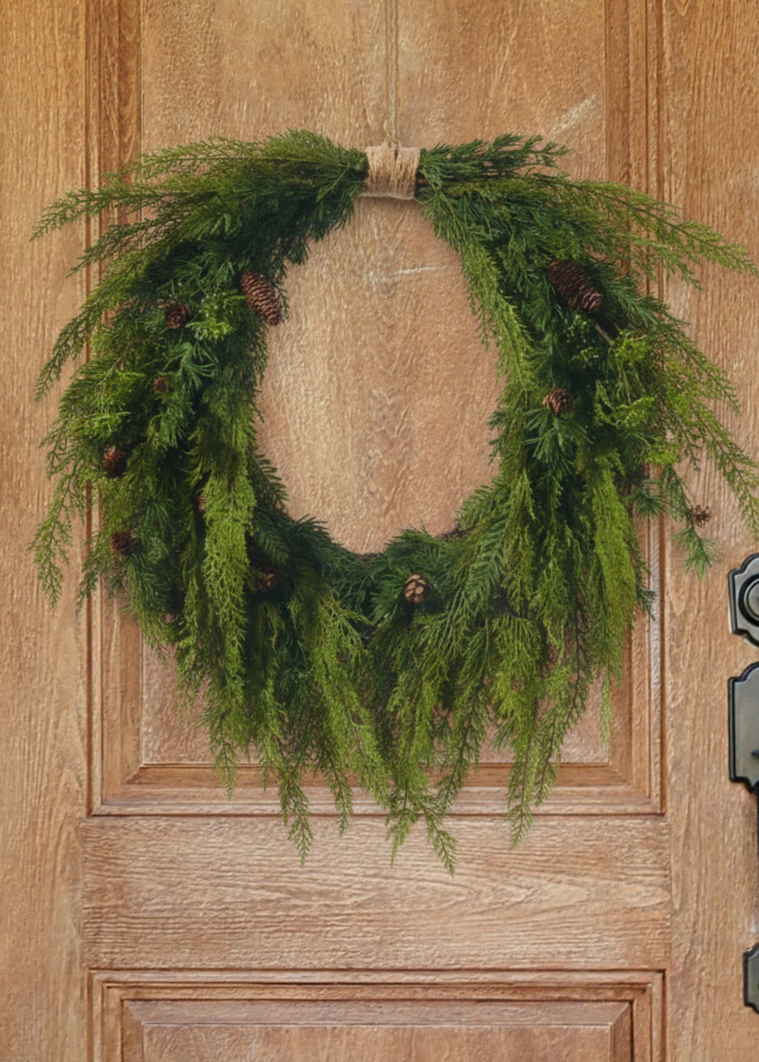 Cedar wreath with pine cones on wood door
