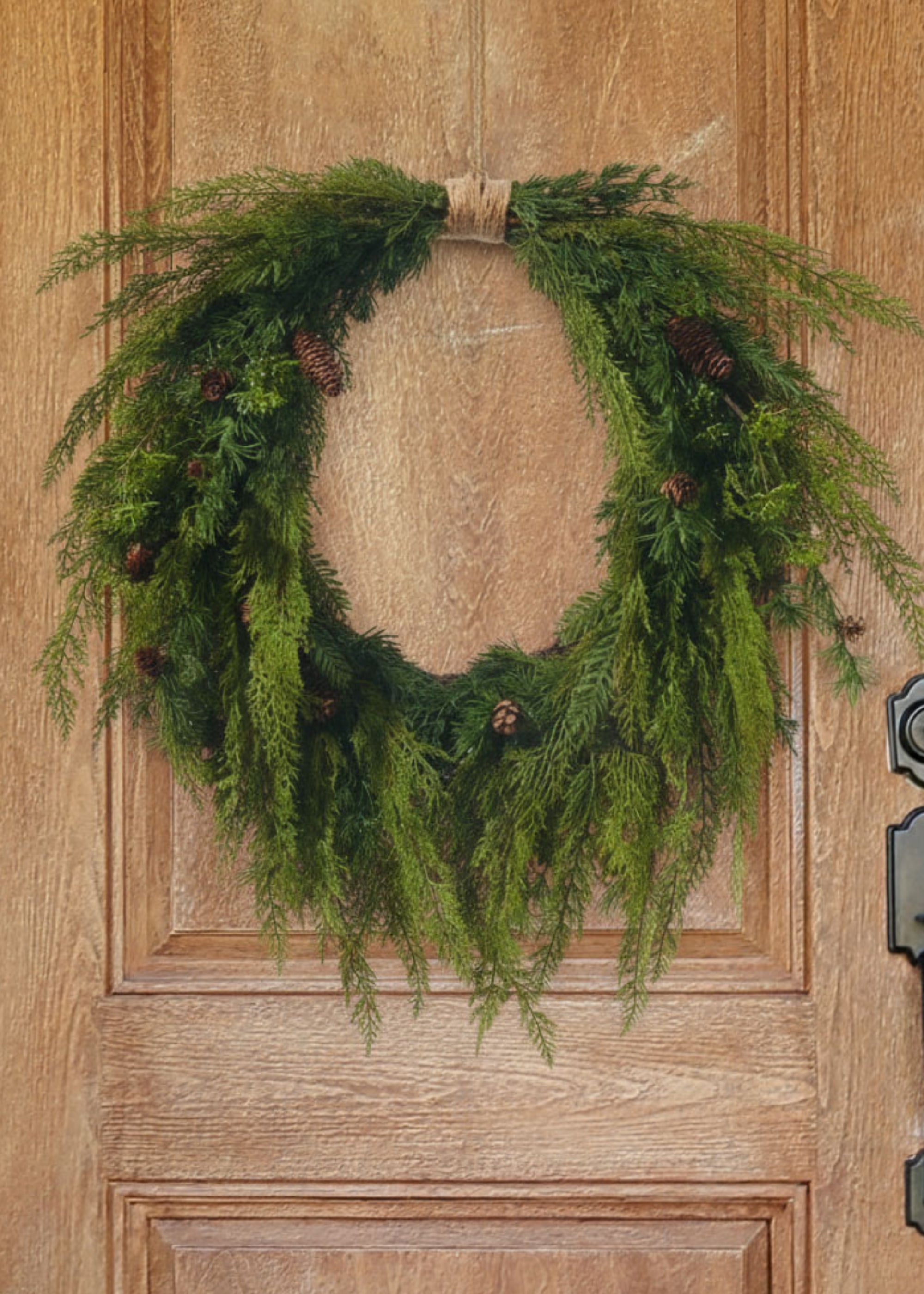 Cedar wreath with pine cones on wood door