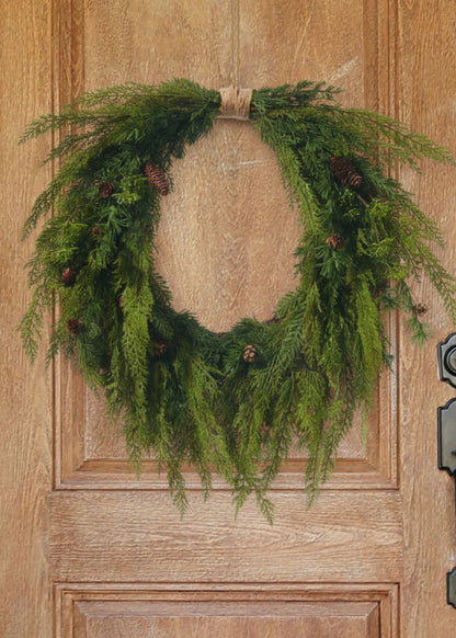 Cedar wreath with pine cones on wood door