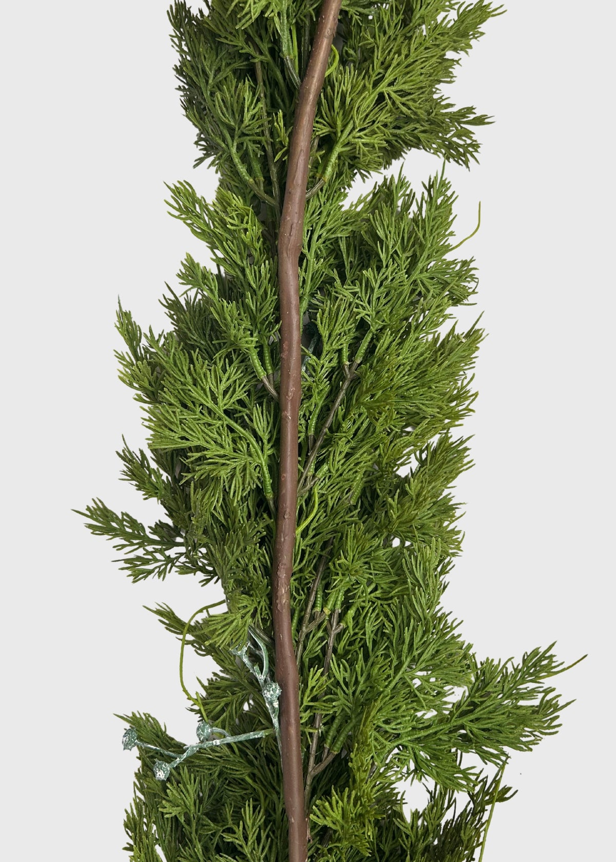 A long artificial green juniper garland with dense needle-like foliage and a brown wire